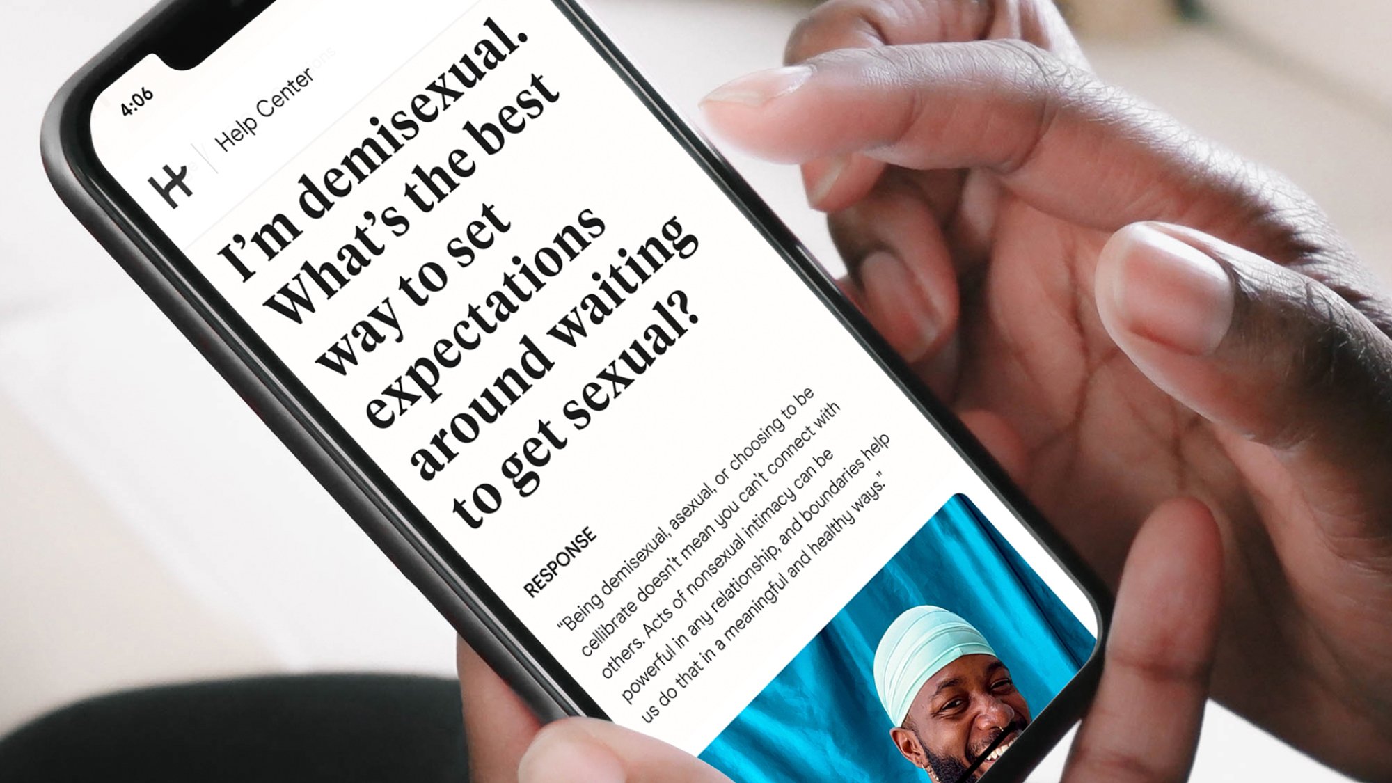 Hinge's new in-app educational guide for LGBTQ users is shown on a smartphone held in a hand.