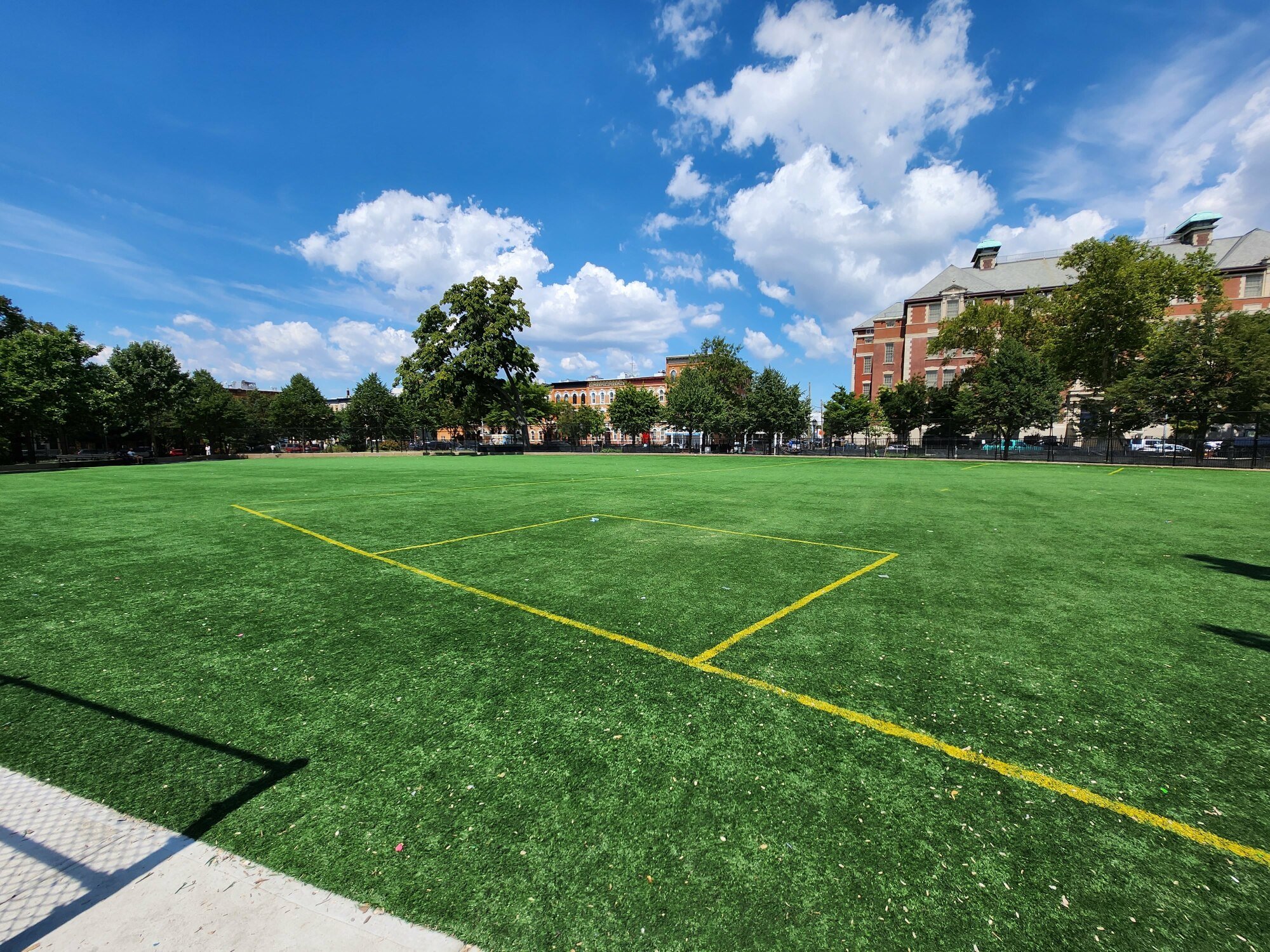 Green field of grass under blue sky with clouds in Brooklyn