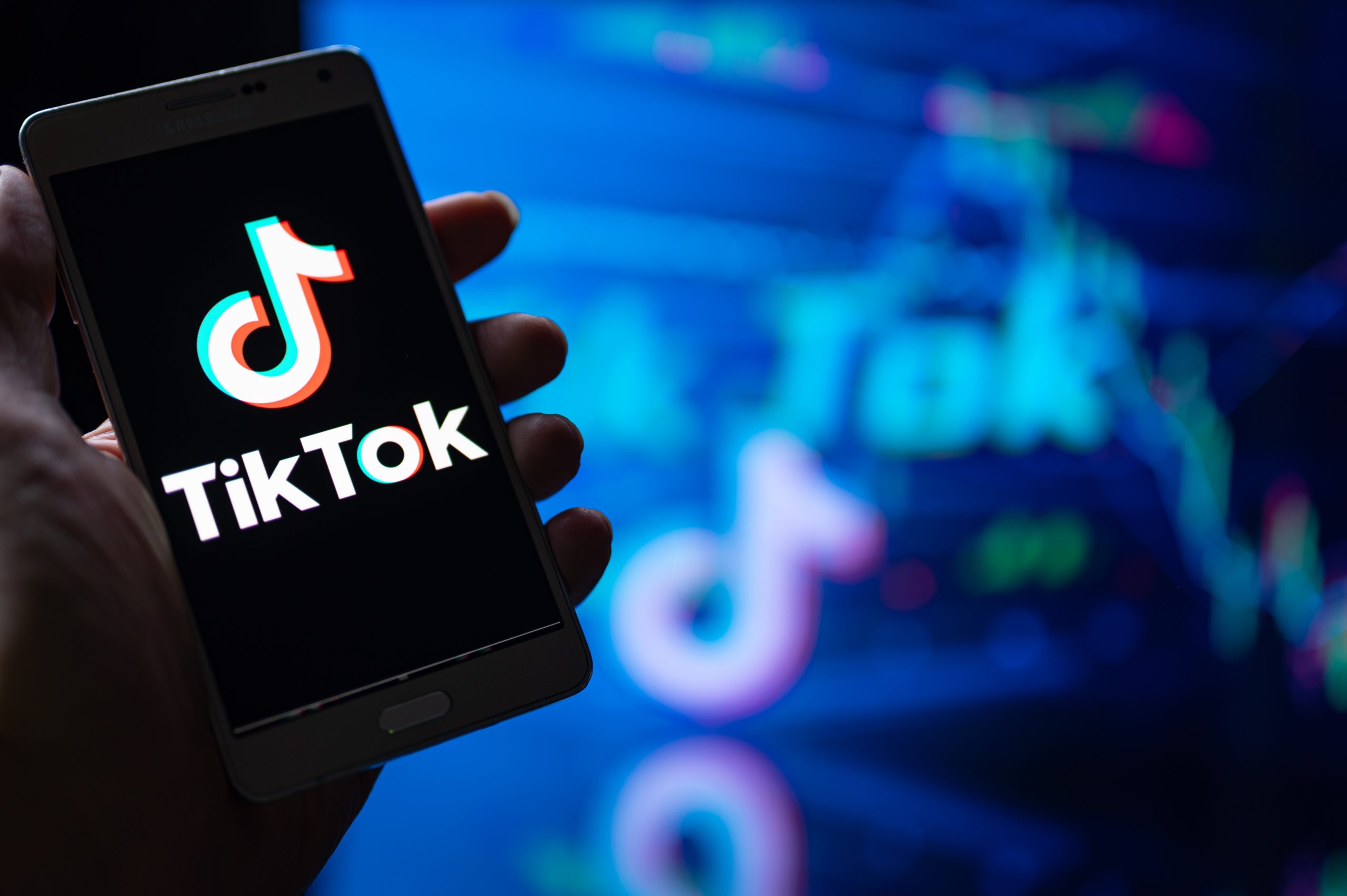 hand holding phone with tiktok logo on it