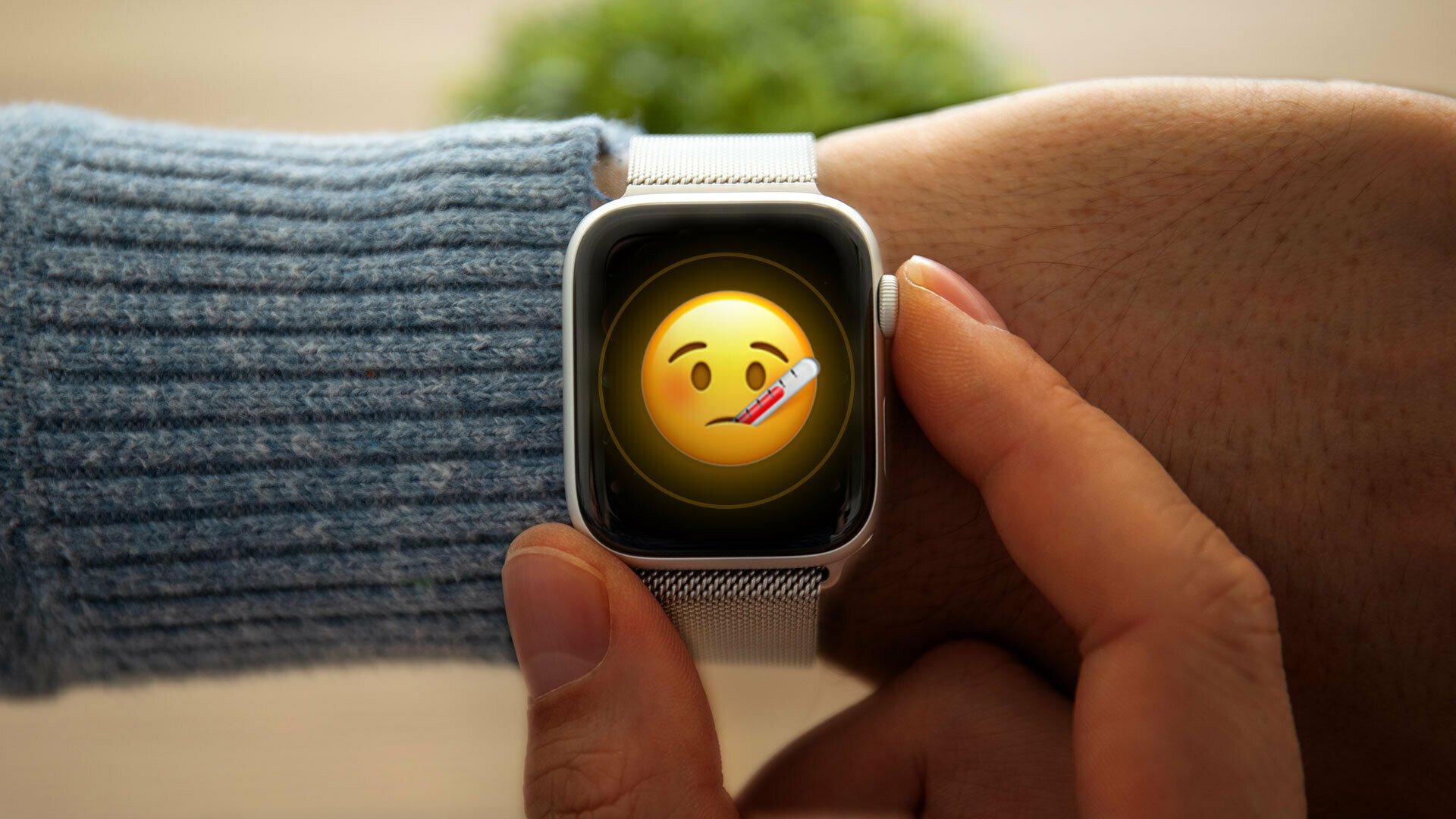 An Apple Watch featuring a sick emoji, being worn on a person's arm.