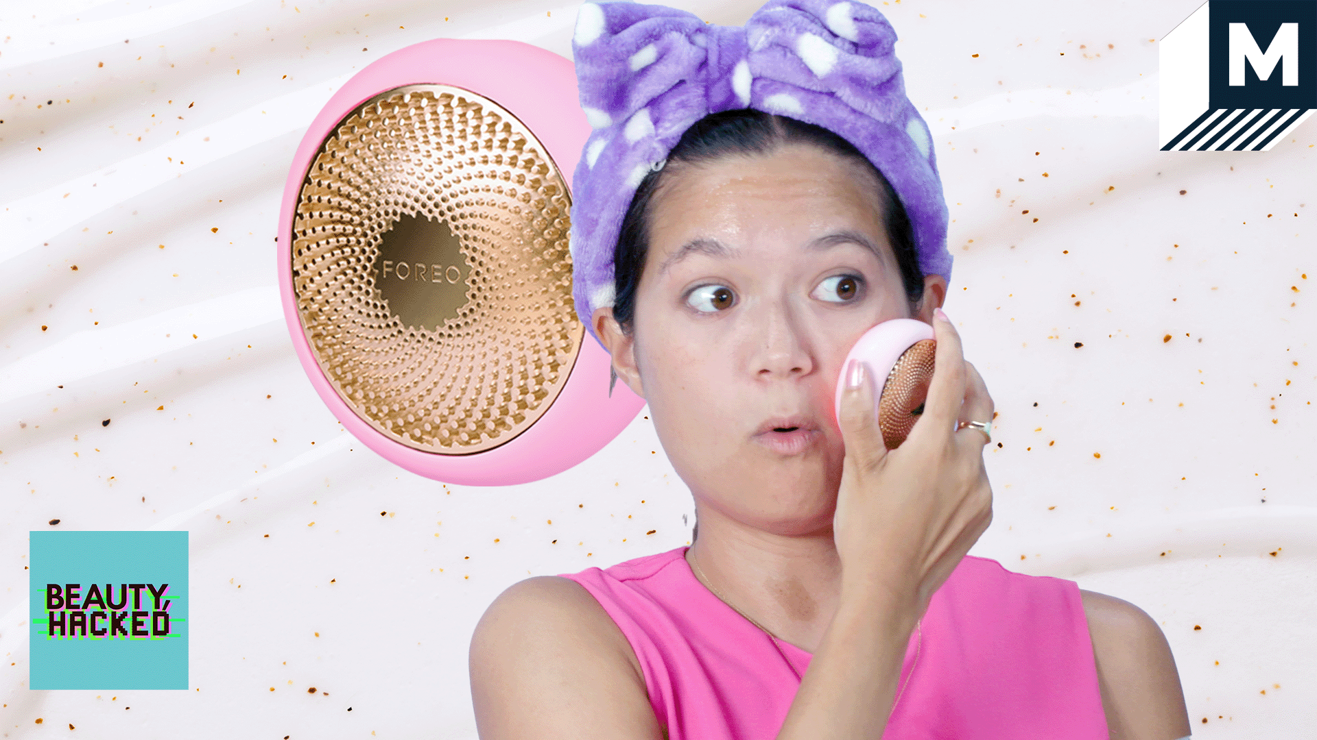 Girl wearing a purple fluffy headband moves a pink puck-shaped object over her face. The puck is also superimposed in the background.