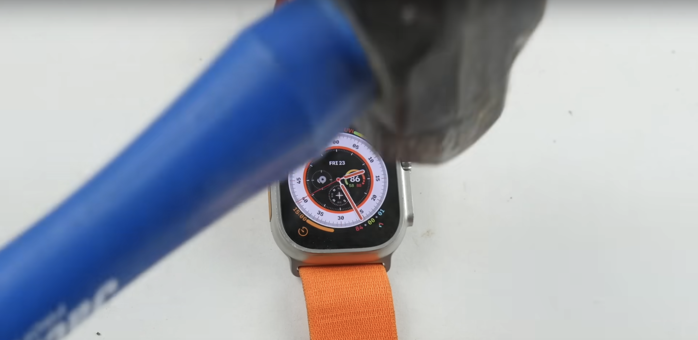 A hammer over an Apple Watch Ultra.