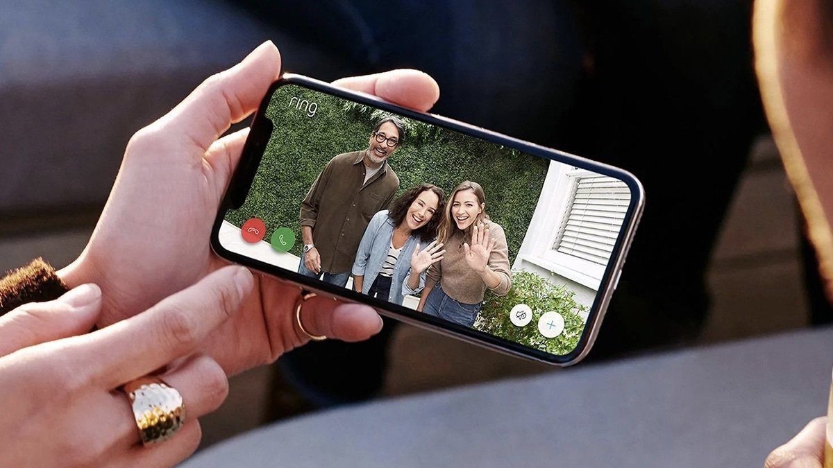 Person using their phone to greet friends with the Ring Video Doorbell Wired.
