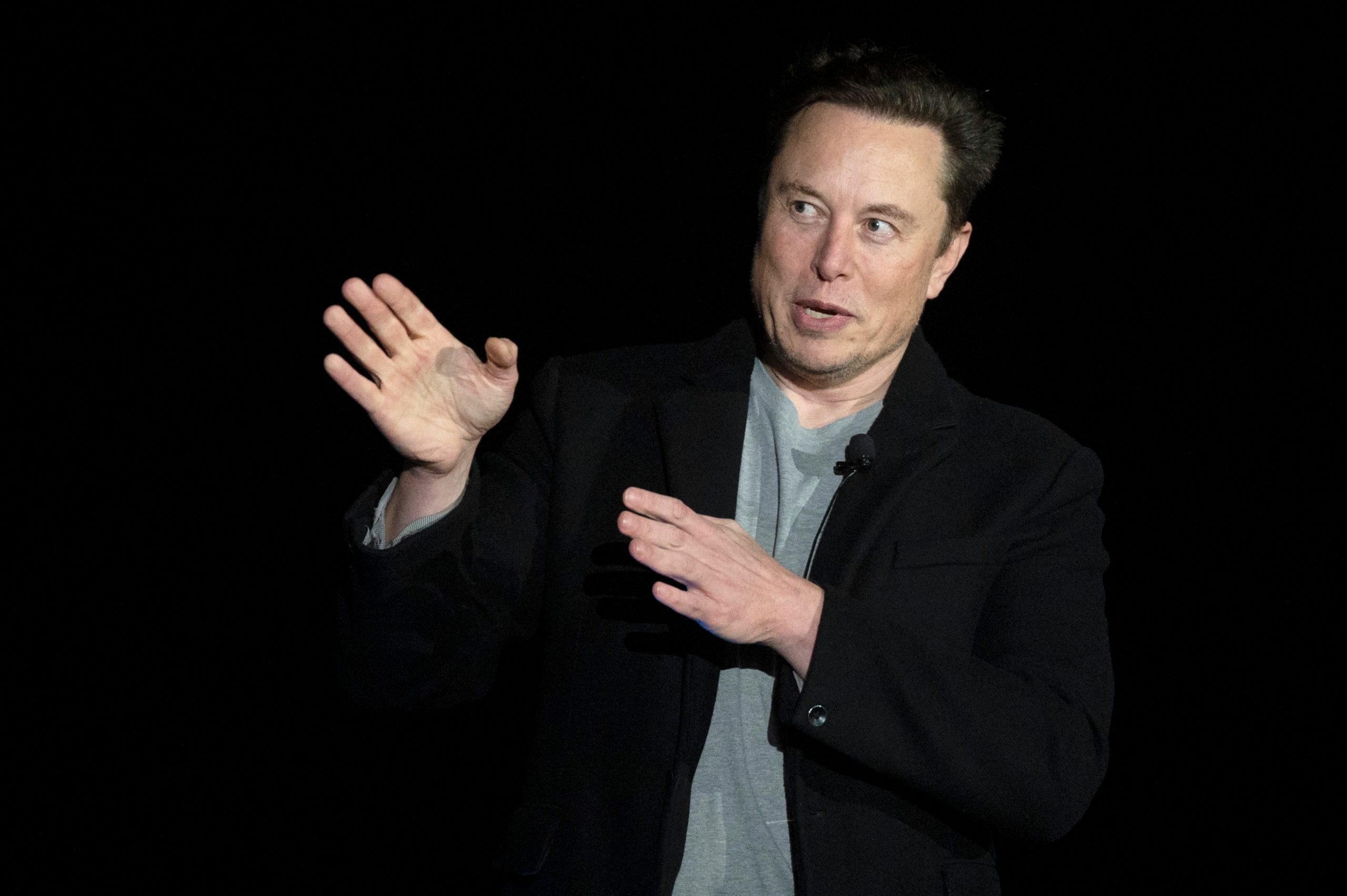 SpaceX and Tesla CEO Elon Musk speaking in front of a black background