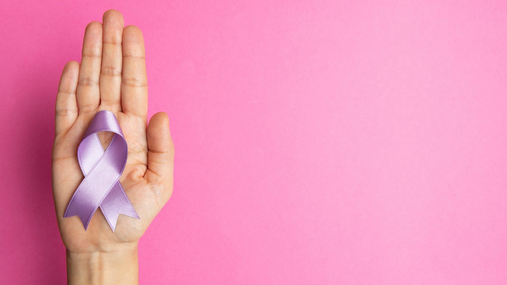 A hand holding a ribbon.