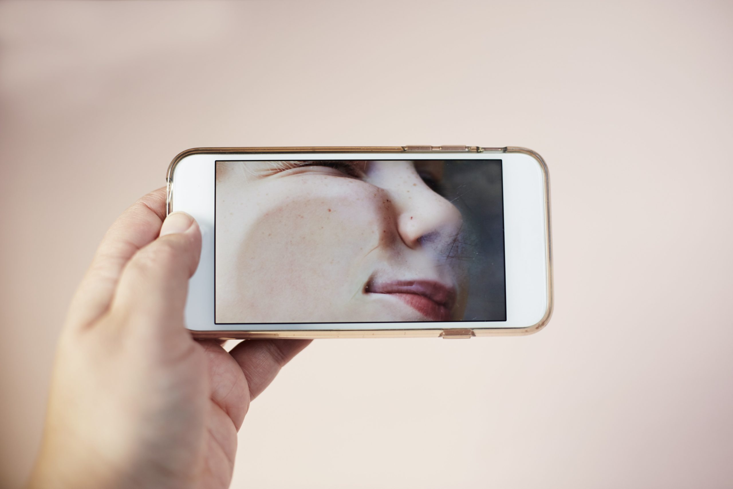 An image of a phone with a picture of a person's face squished against the camera.