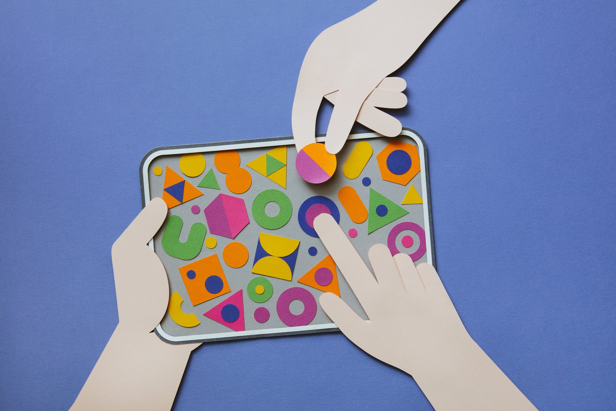 Hands pulling prefab pieces out of a tray for graphic design