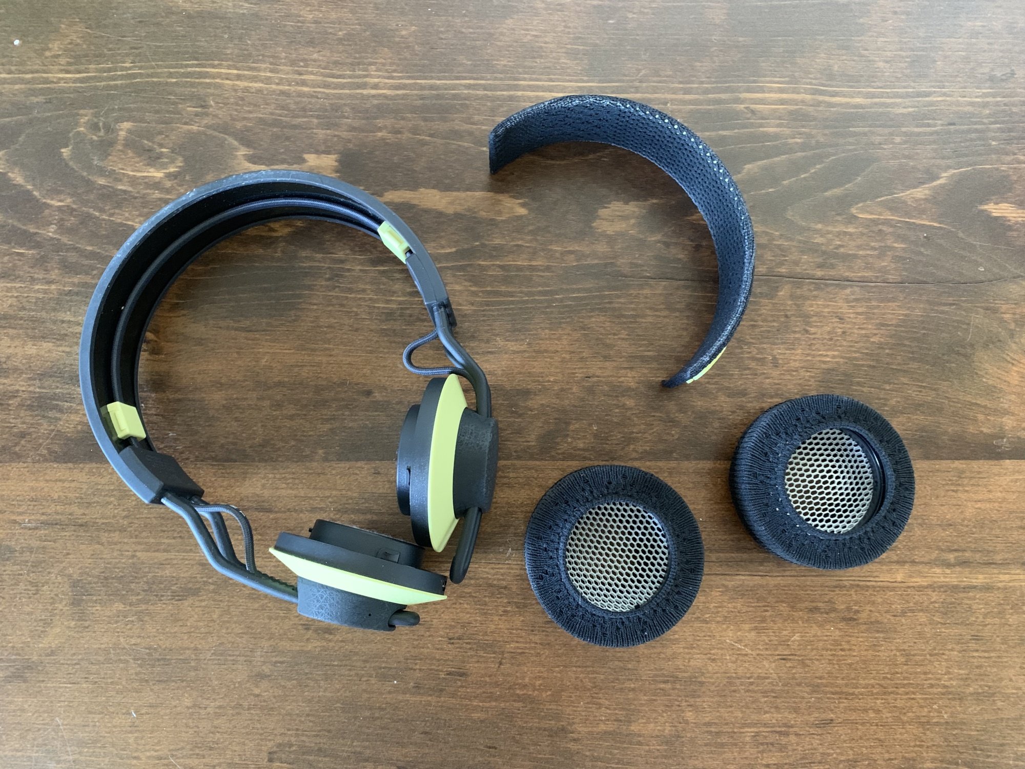 The headphone broken down into pieces: the main headphone unit, the removable headband and the removable earpieces.