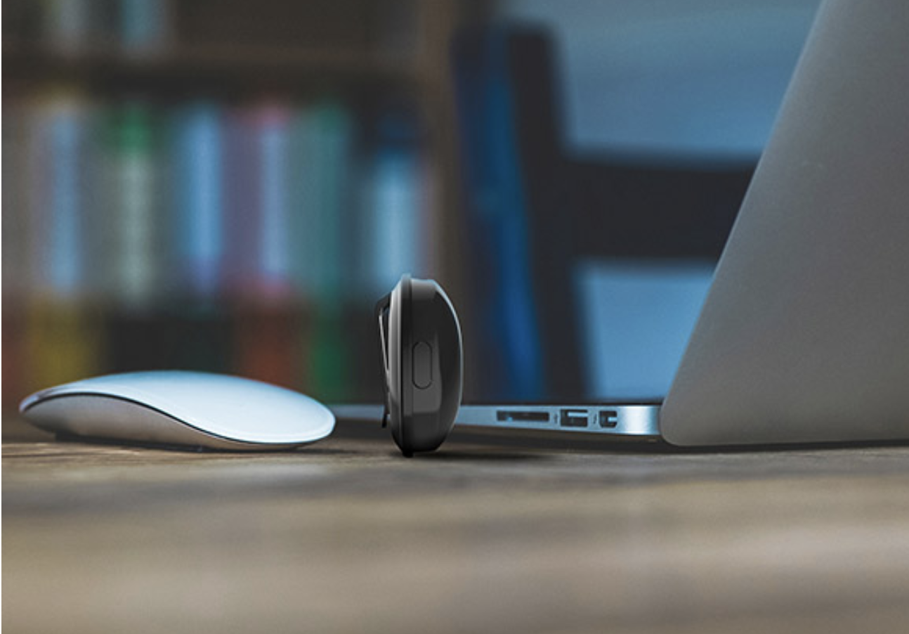 A tiny camera next to a laptop.