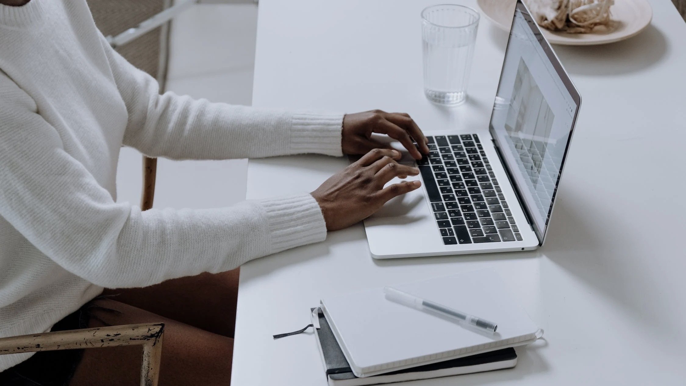 Person typing on their MacBook.