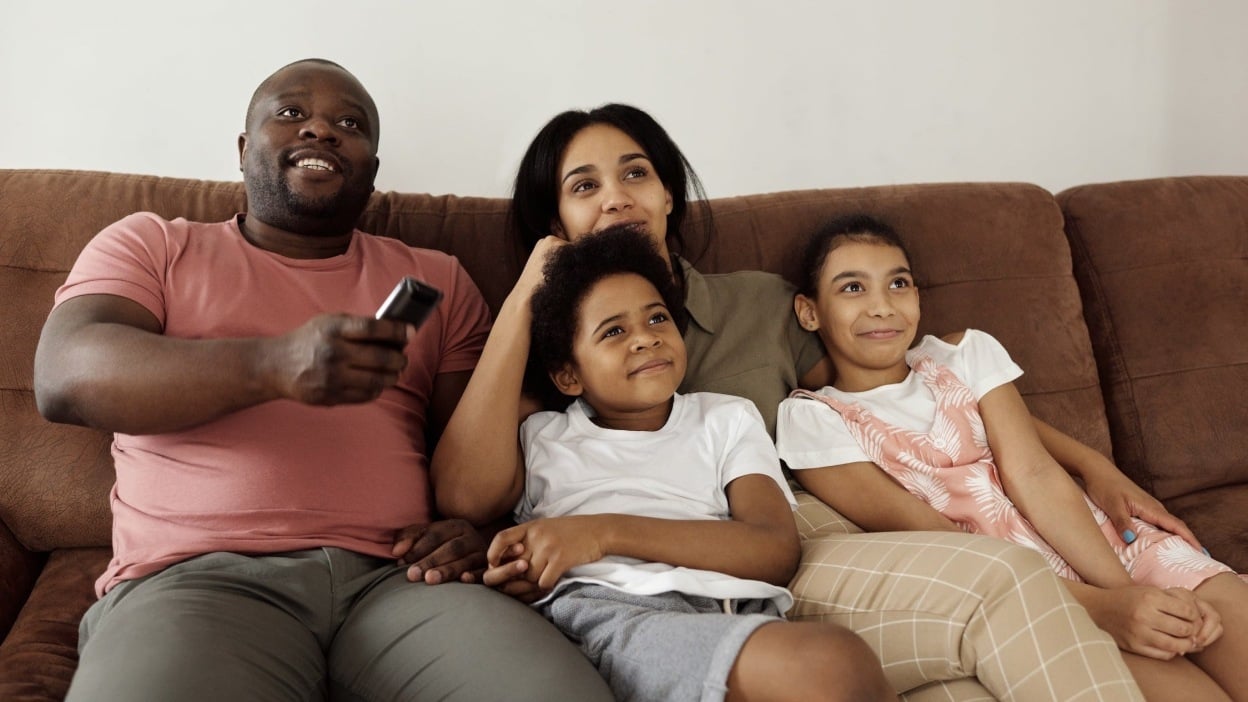 Family sat together with remote