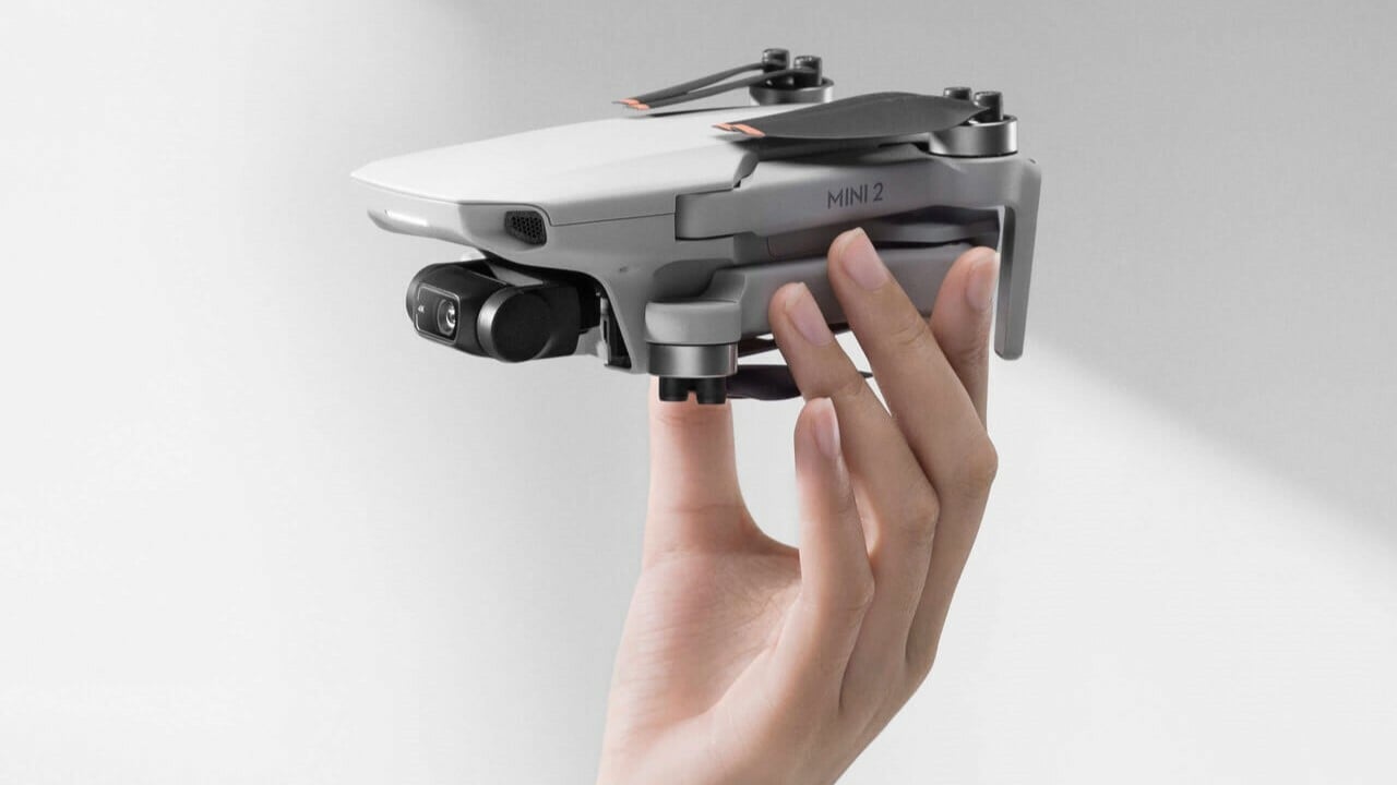 folded DJI Mini 2 drone held by hand