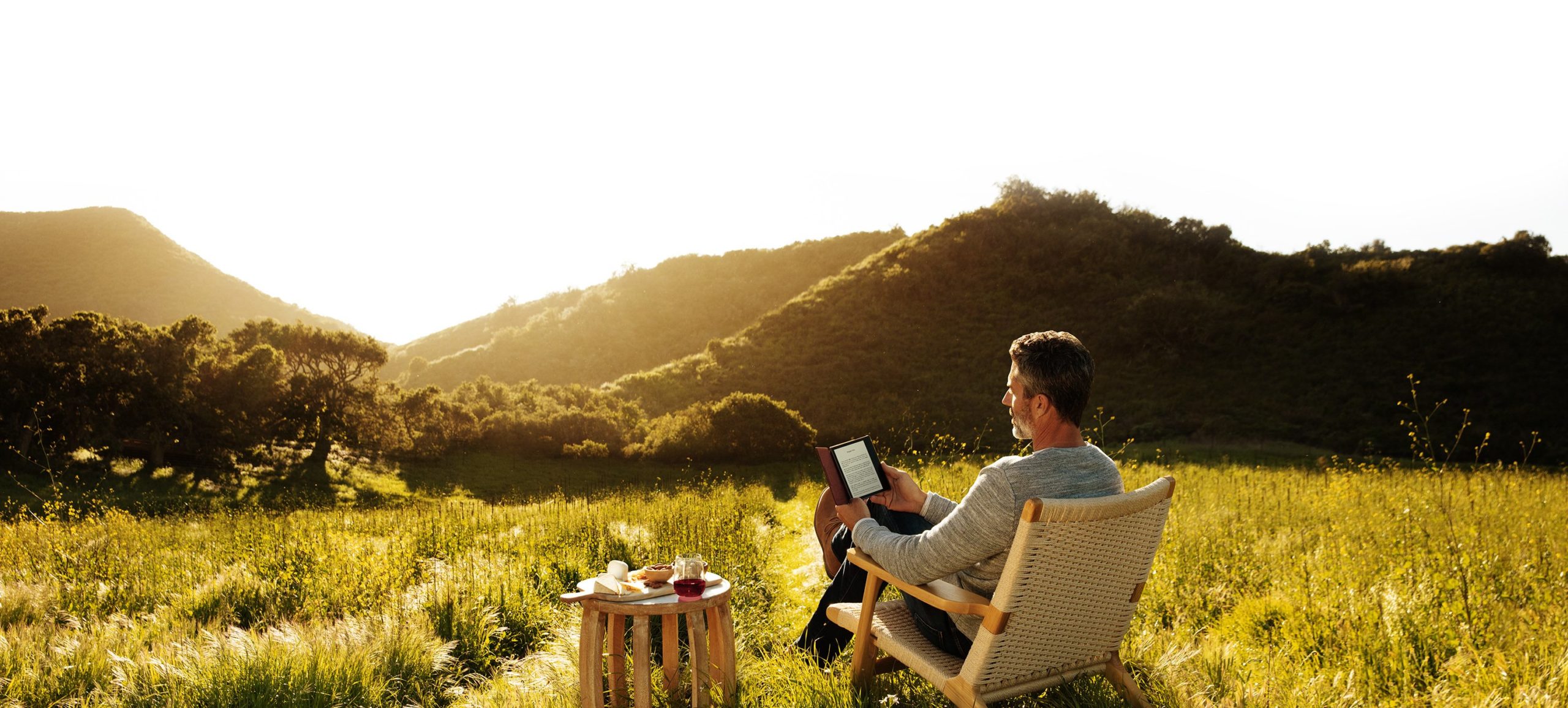 man reading Amazon Kindle outdoors