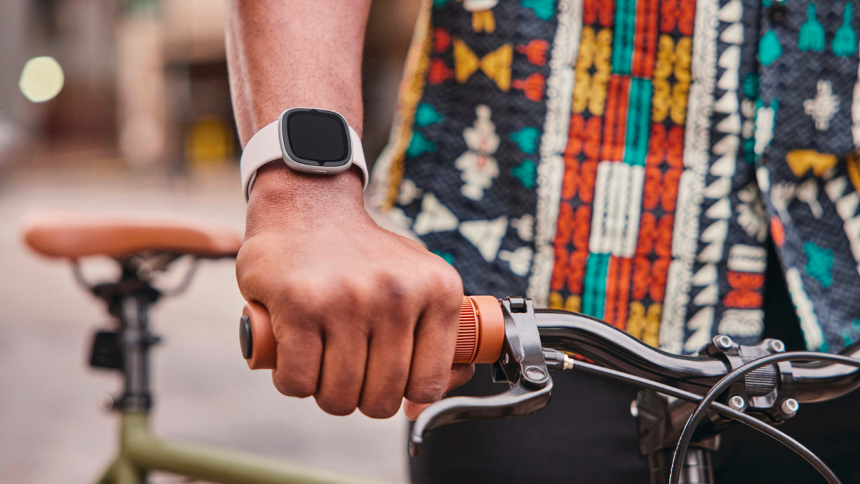 person wearing fitbit while holding bike handlebars