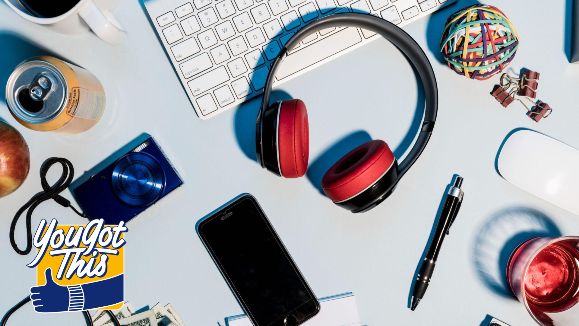 Headphones on desk with other tech gears like a phone