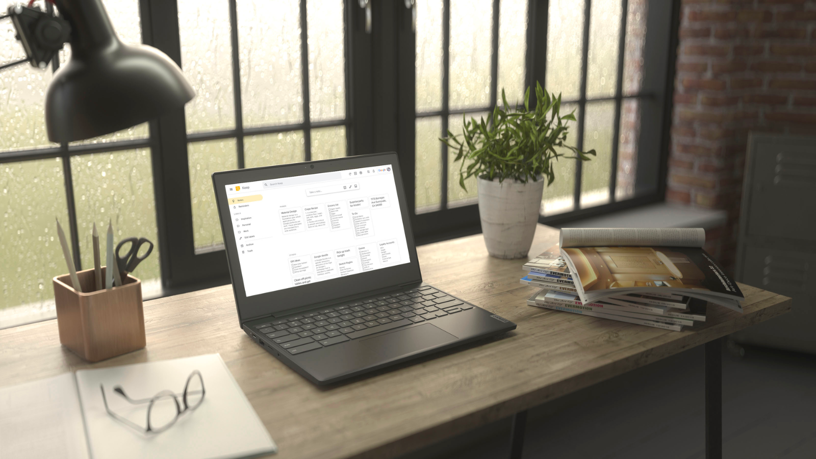 Lenovo Chromebook sitting atop desk next to pad of paper and stack of magazines