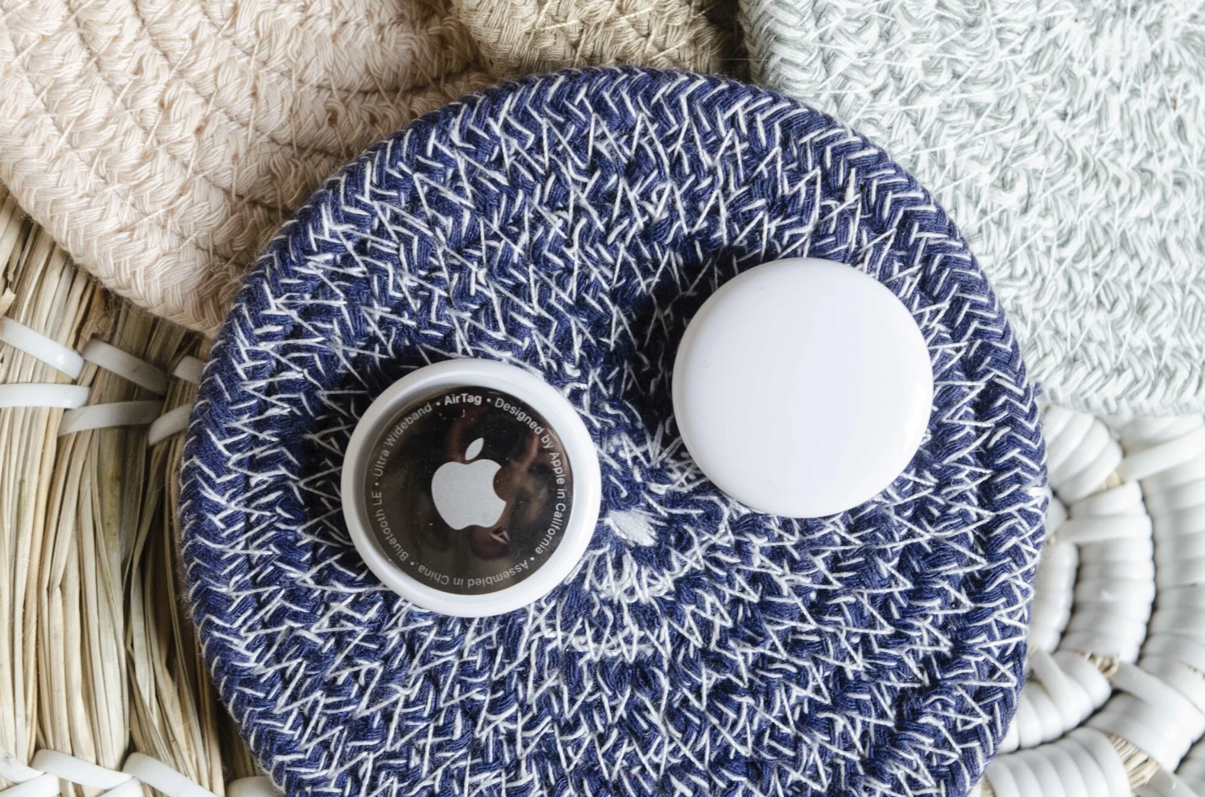 Two AirTags on top of a blue and white potholder