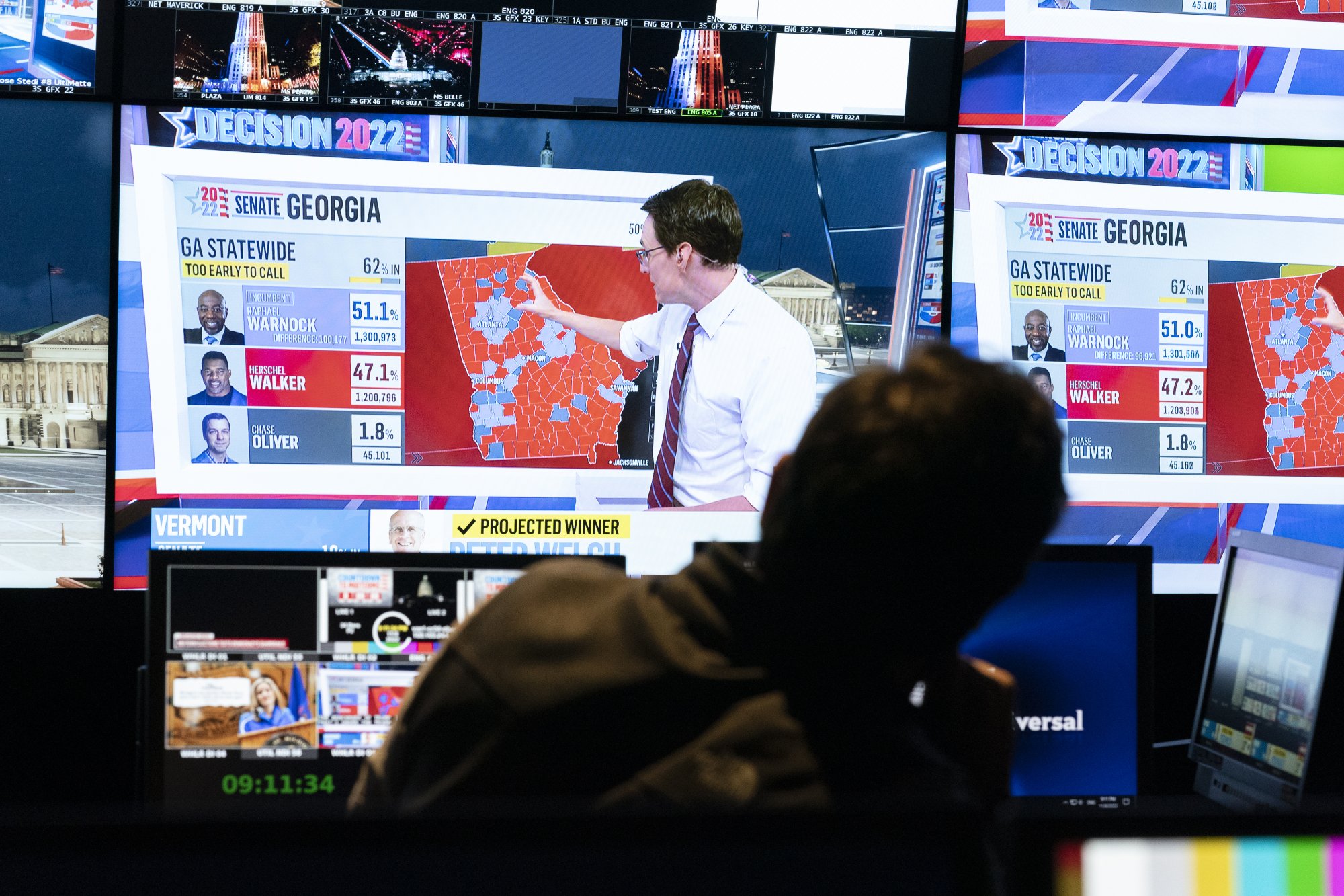 The silhouette of a man from behind. In front of him are two double monitors, one shows Karnacki mid-spiel.