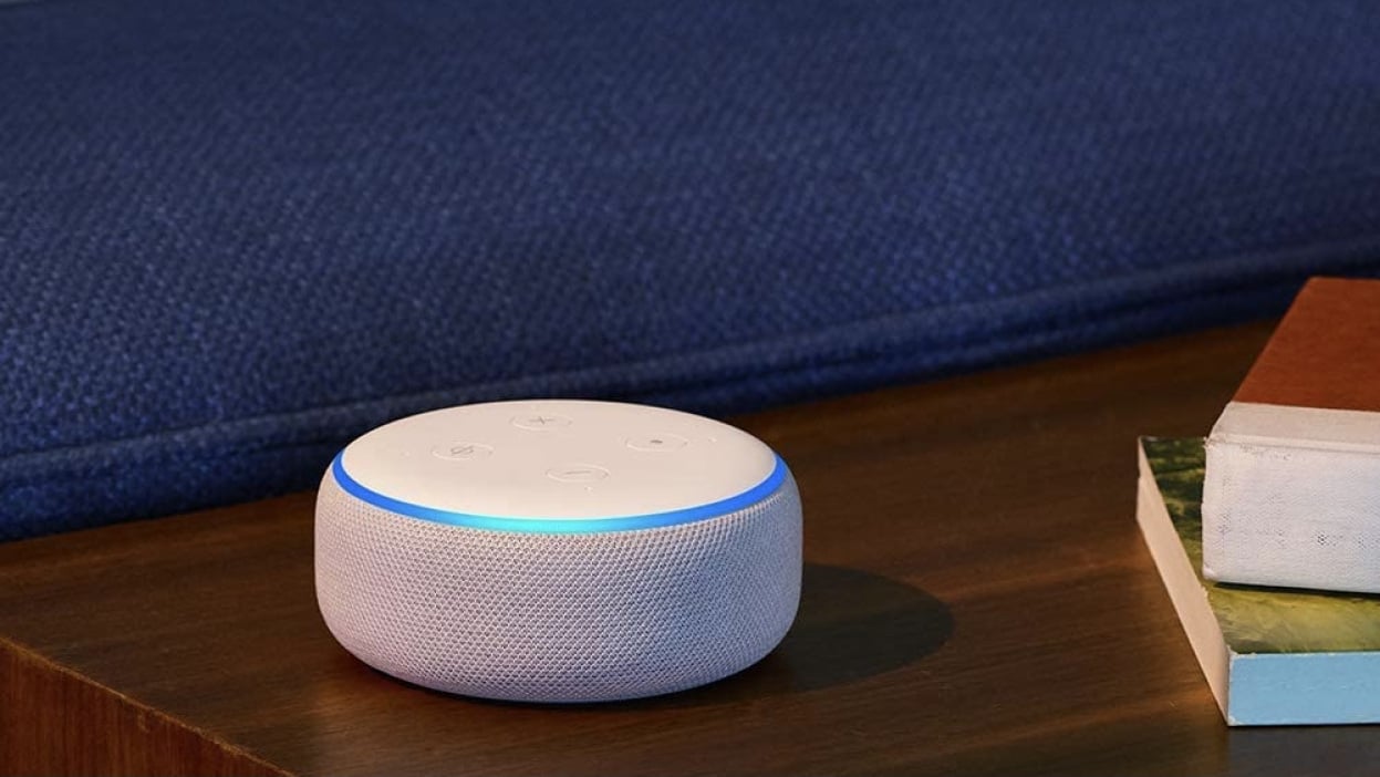 Amazon Echo Dot on shelf next to two books. 