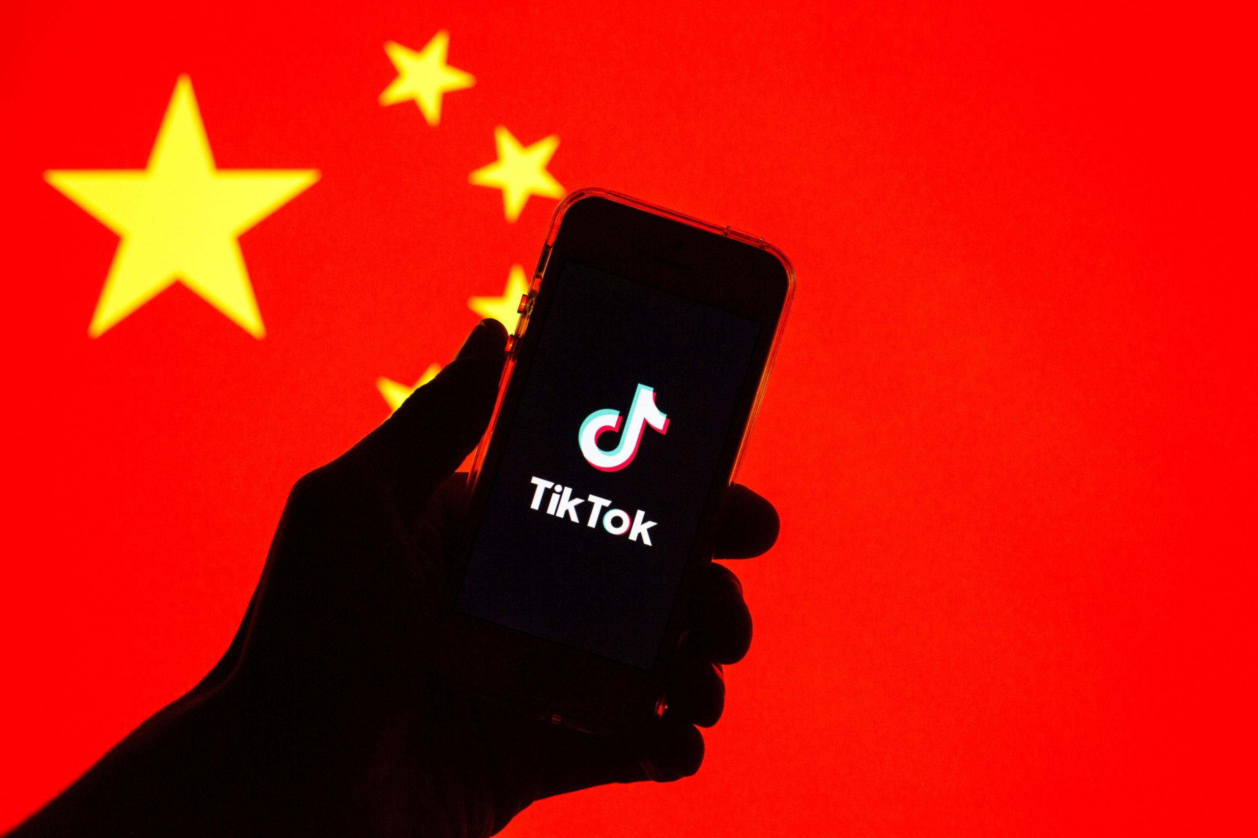 A phone with the TikTok logo in front of the Chinese flag