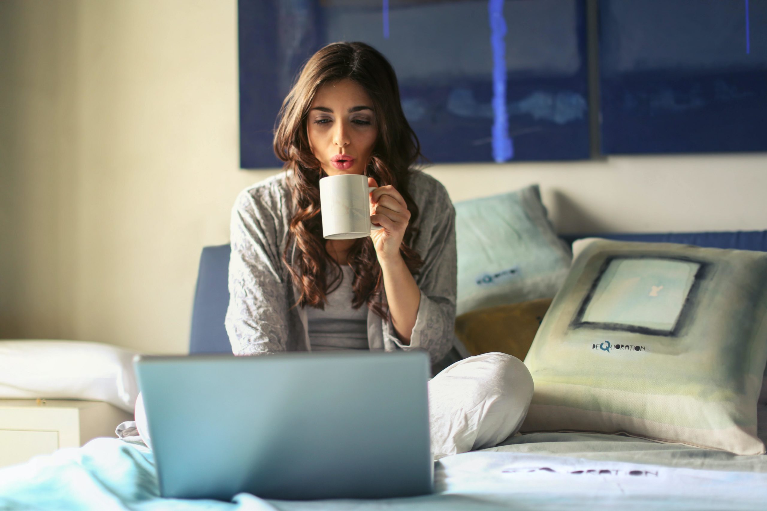 Girl with mug looking at laptop