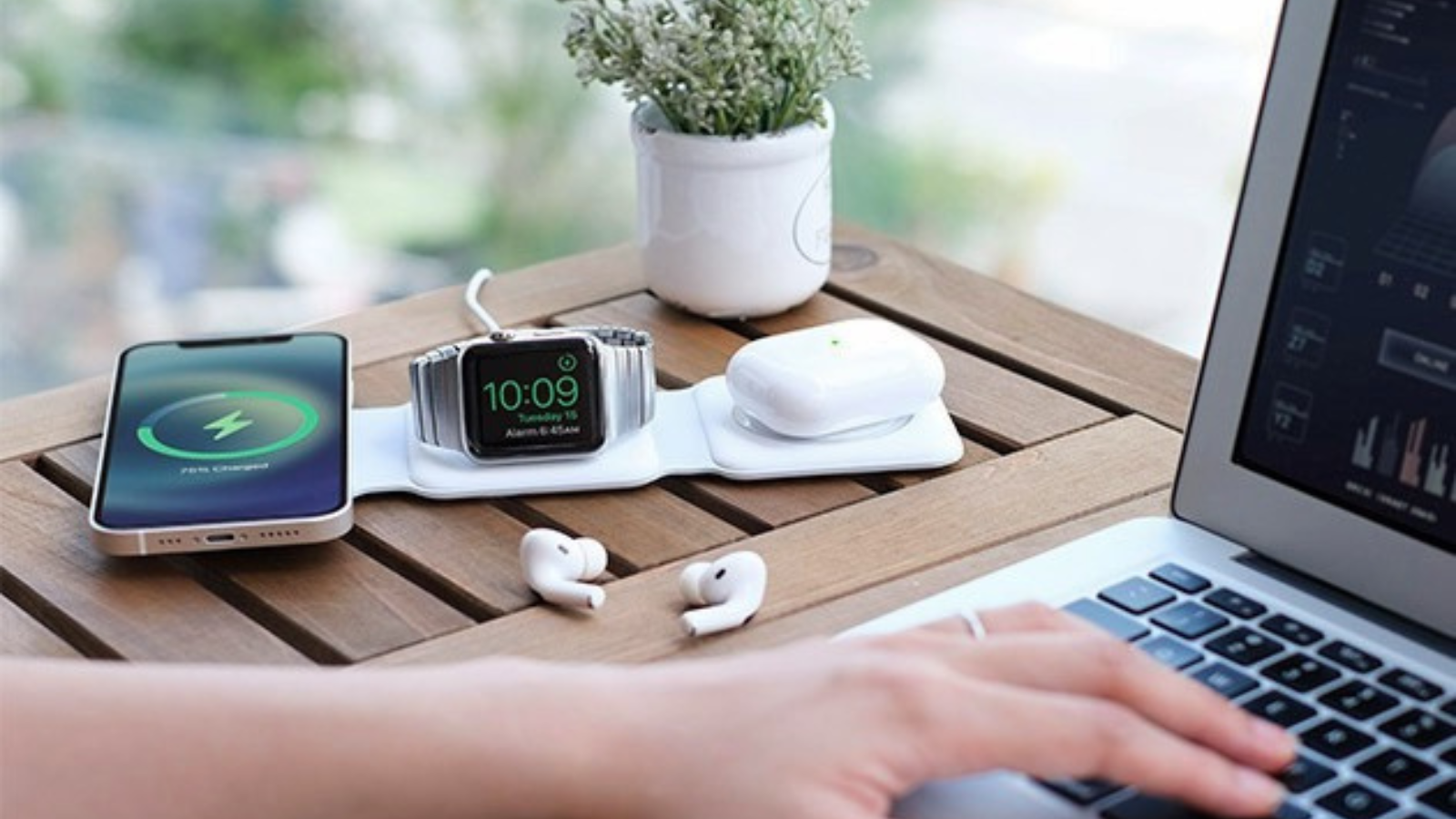 person on computer with gadgets charging on magstack charging station