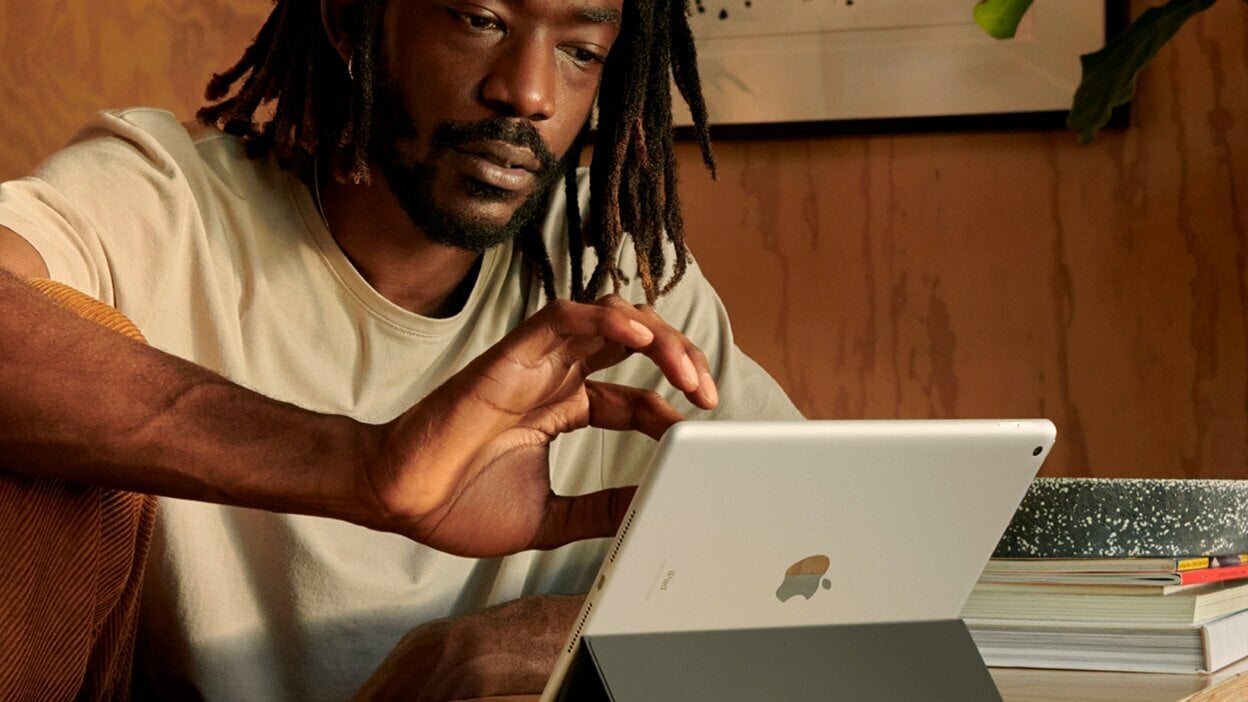 A man is using the Apple iPad in his room