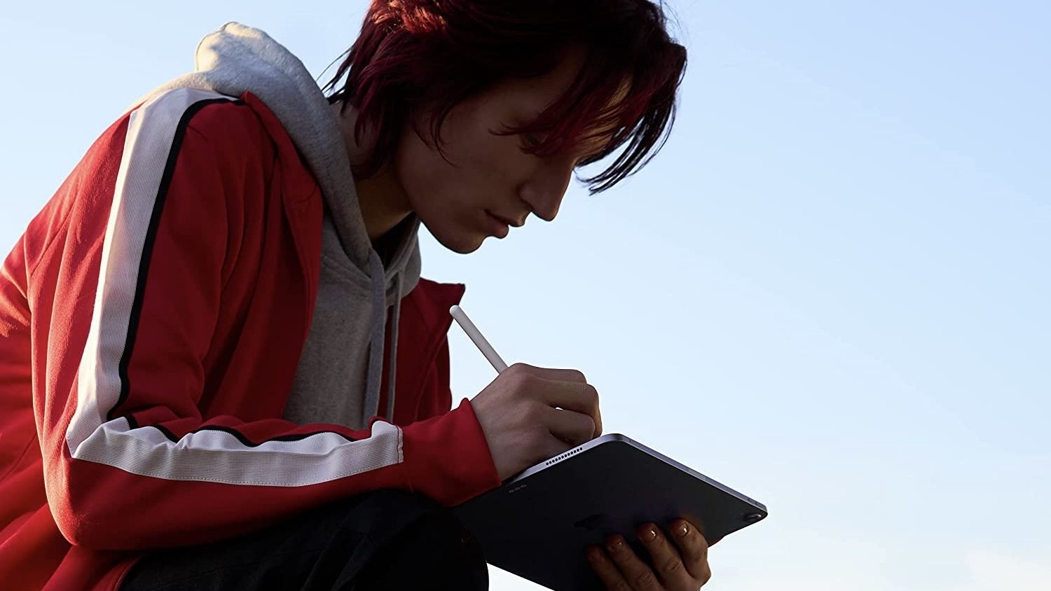 person sitting and using apple pencil with ipad air