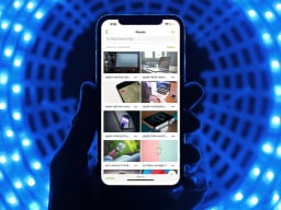 hand holding phone using koofr cloud storage with blue background