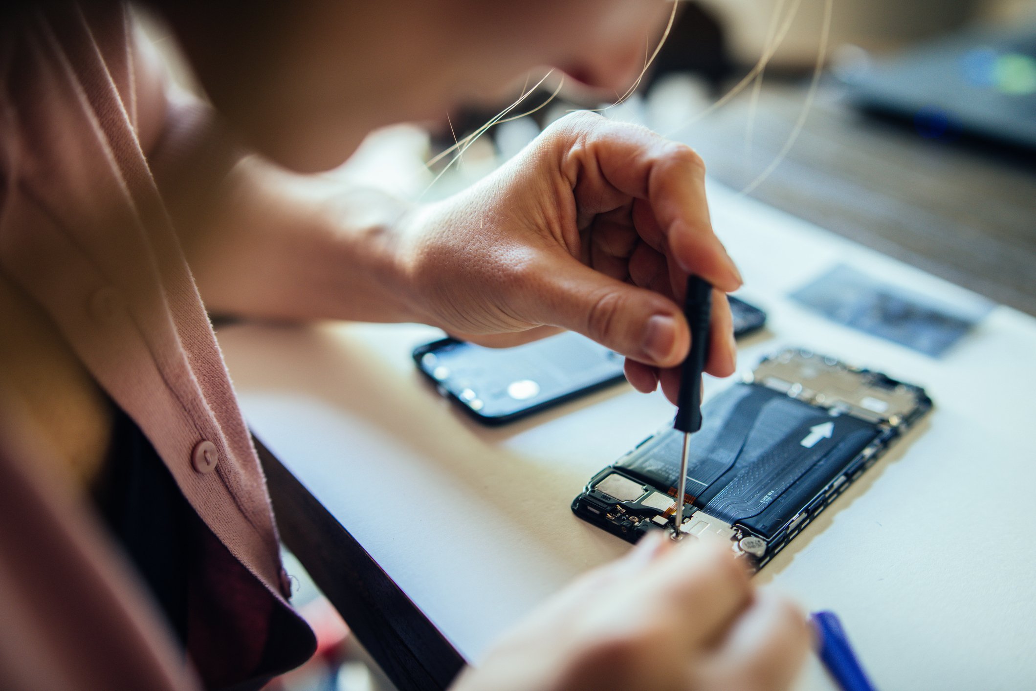 Woman repairing her own smartphone