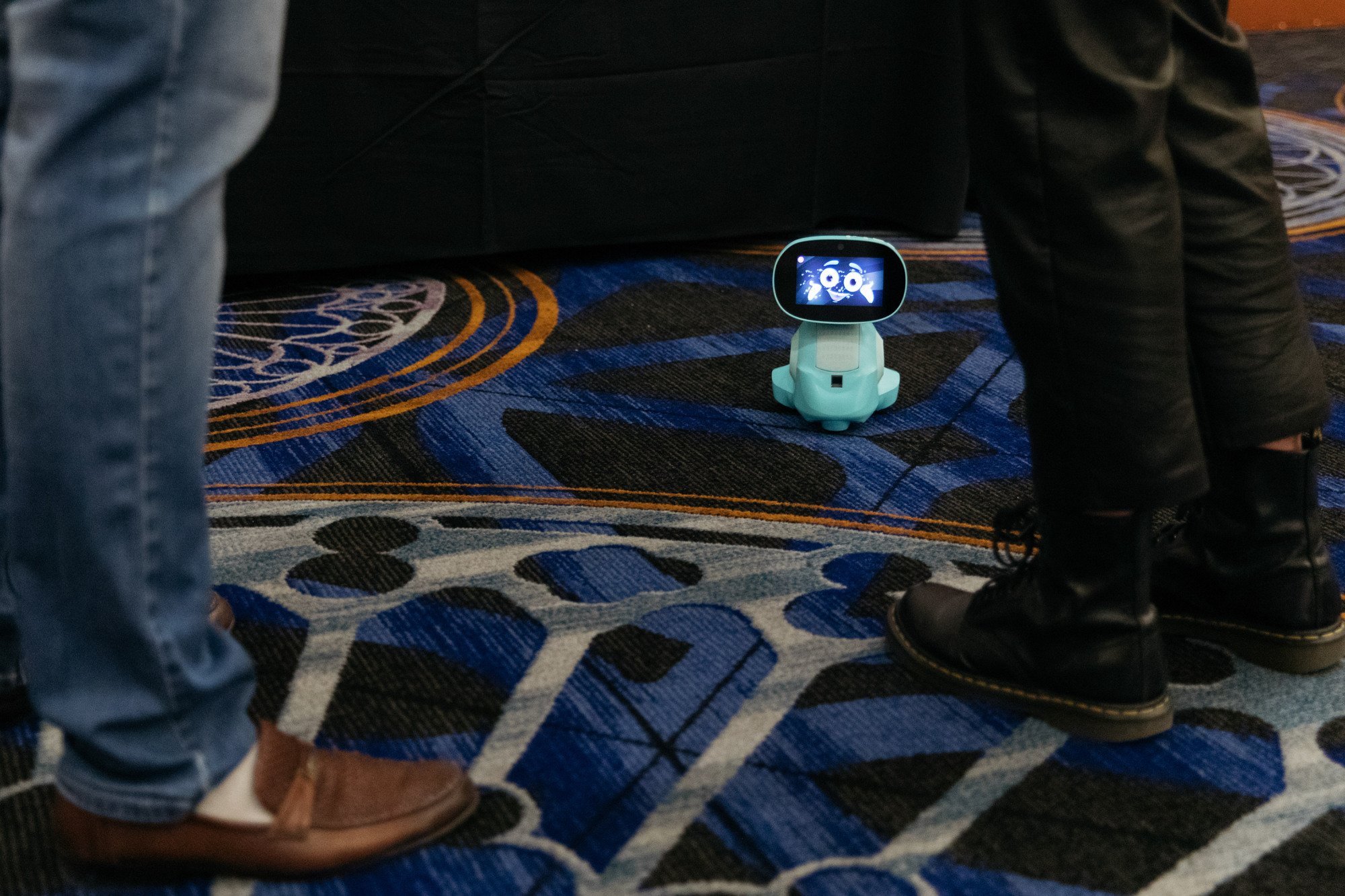 tiny robot on ground next to feet