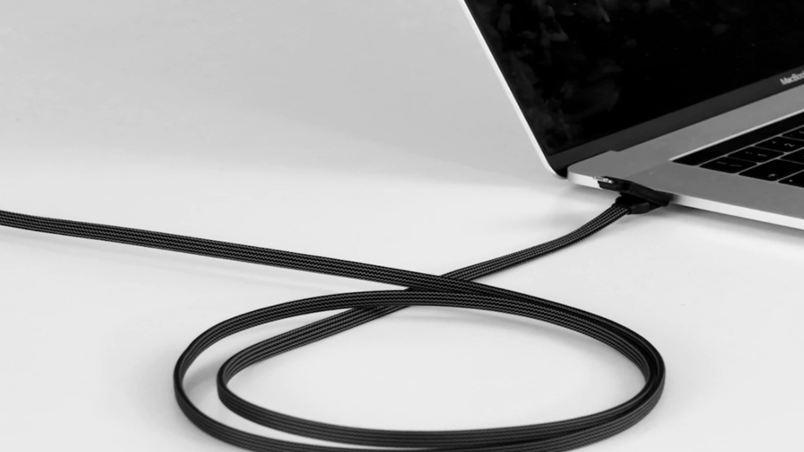 macbook with incharge x max charging cable plugged into port