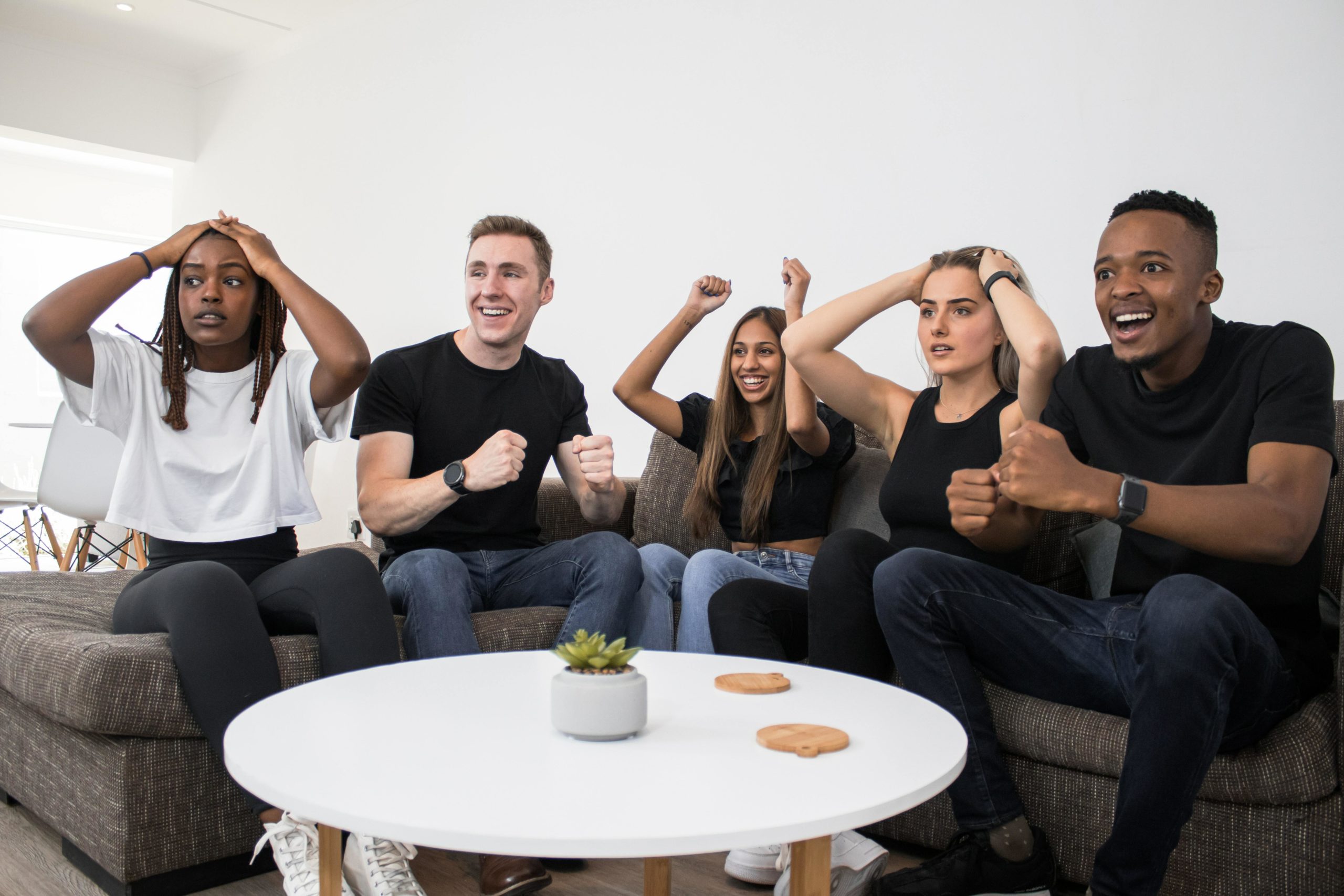 Group of people cheering on sofa