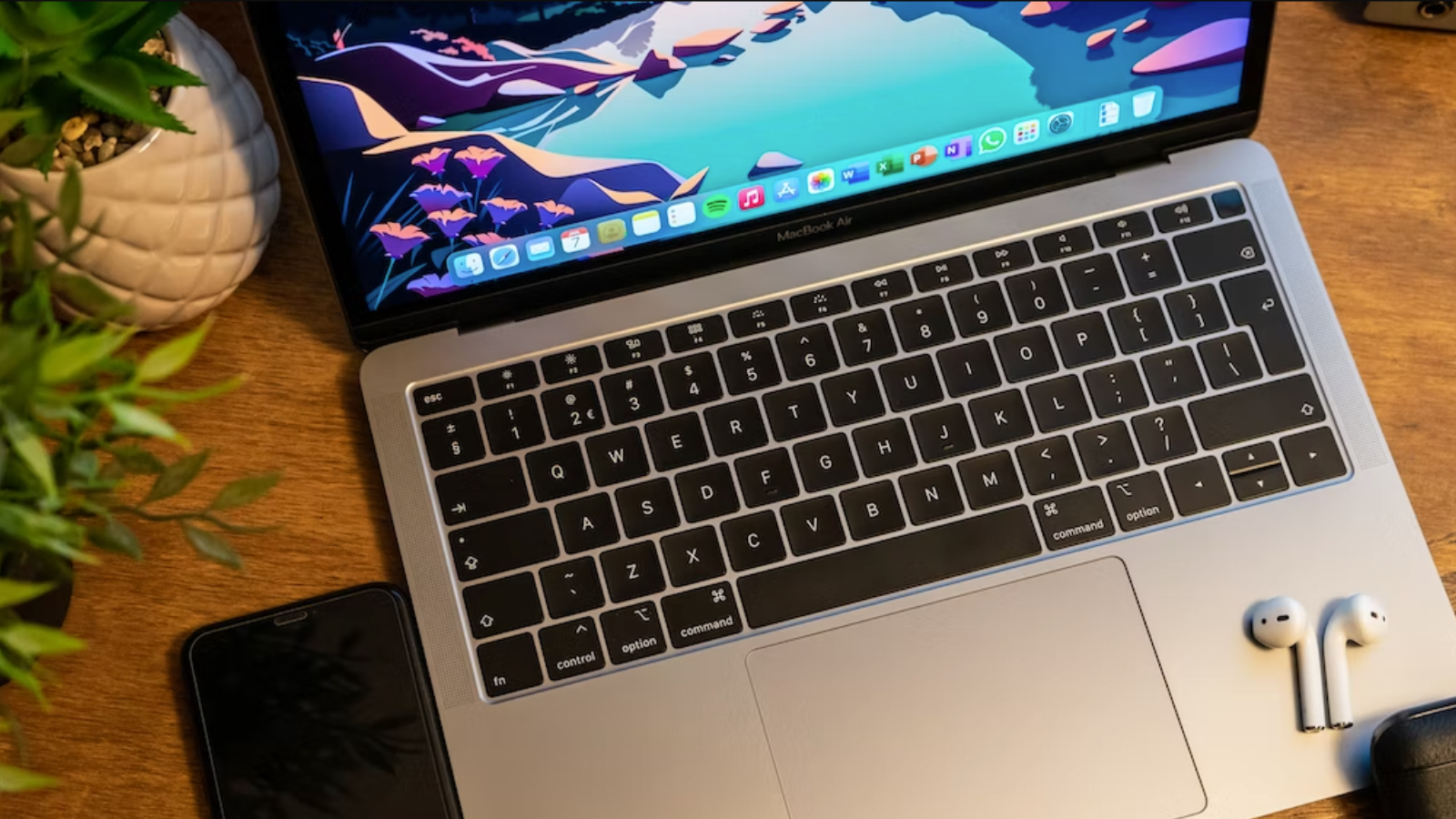 macbook air sitting on desktop with airpods