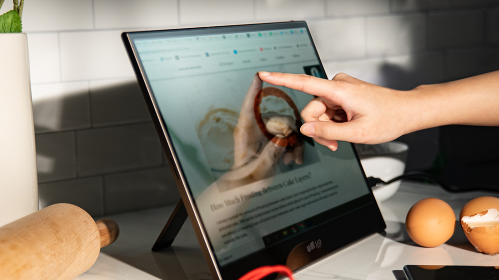 person using portable monitor on countertop in kitchen