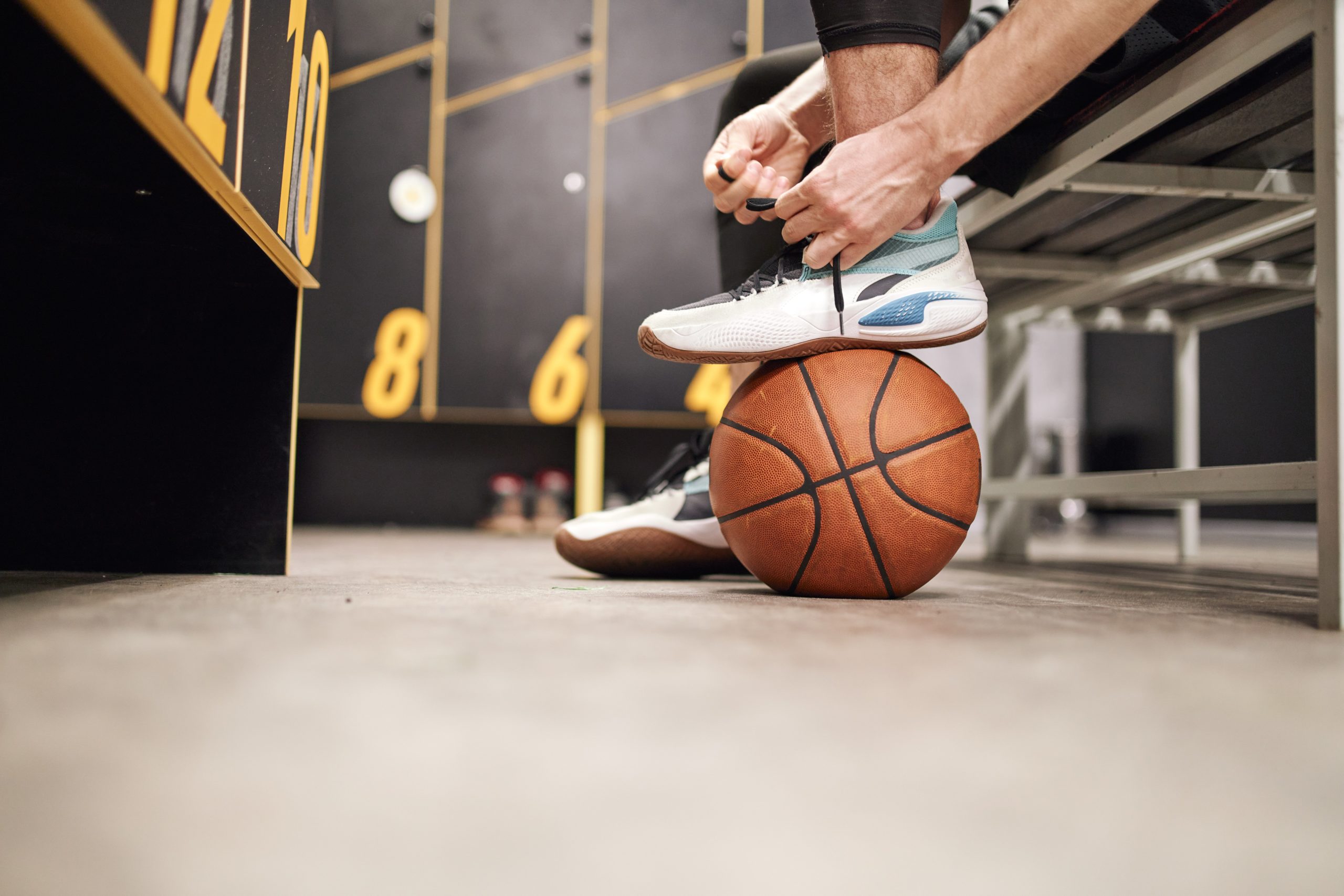 Man laces up sneakers for basketball