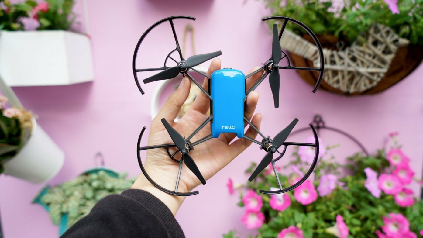 drone held in hand above pink background