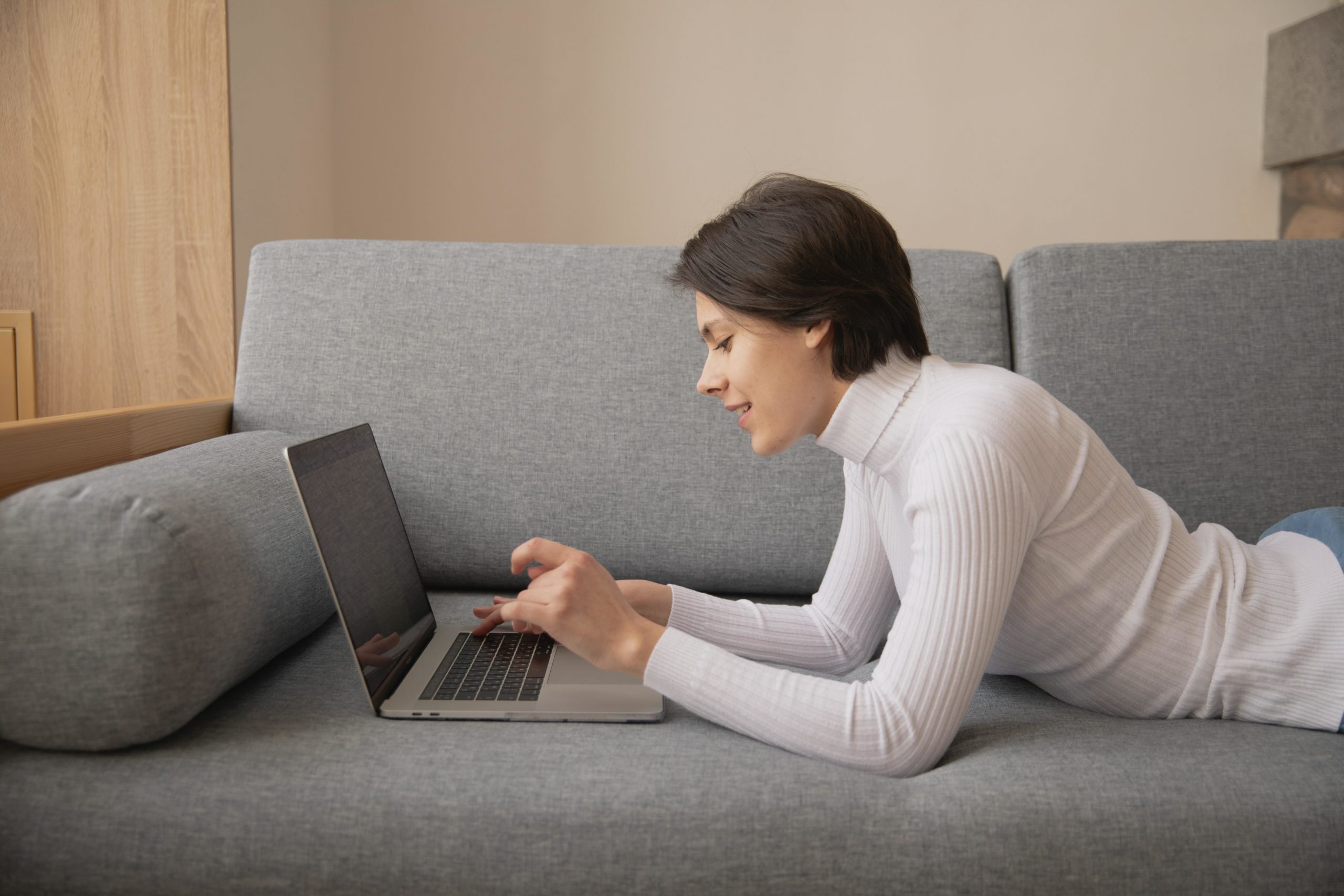 Person looking at laptop on sofa