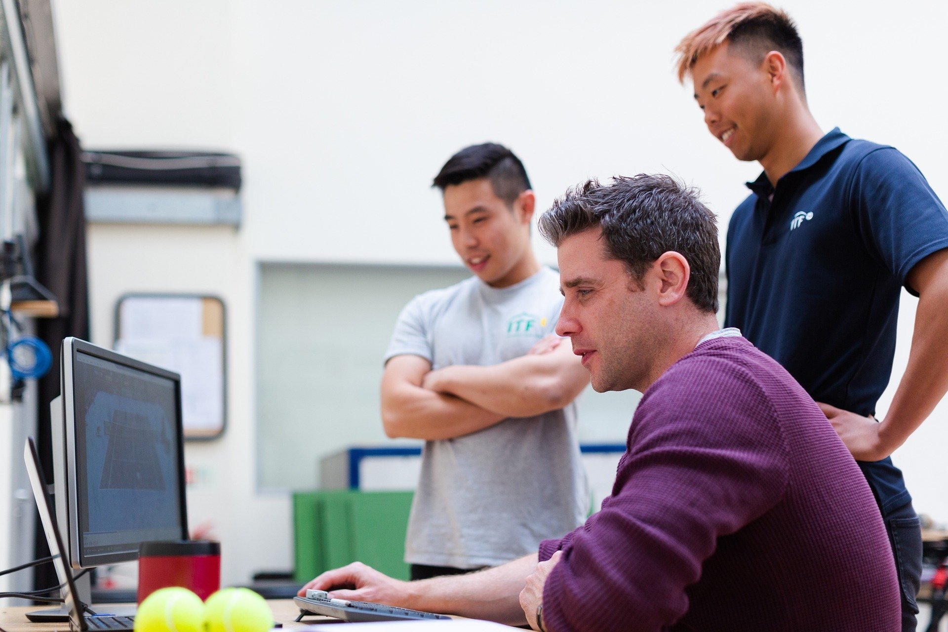 Three men looking at laptop