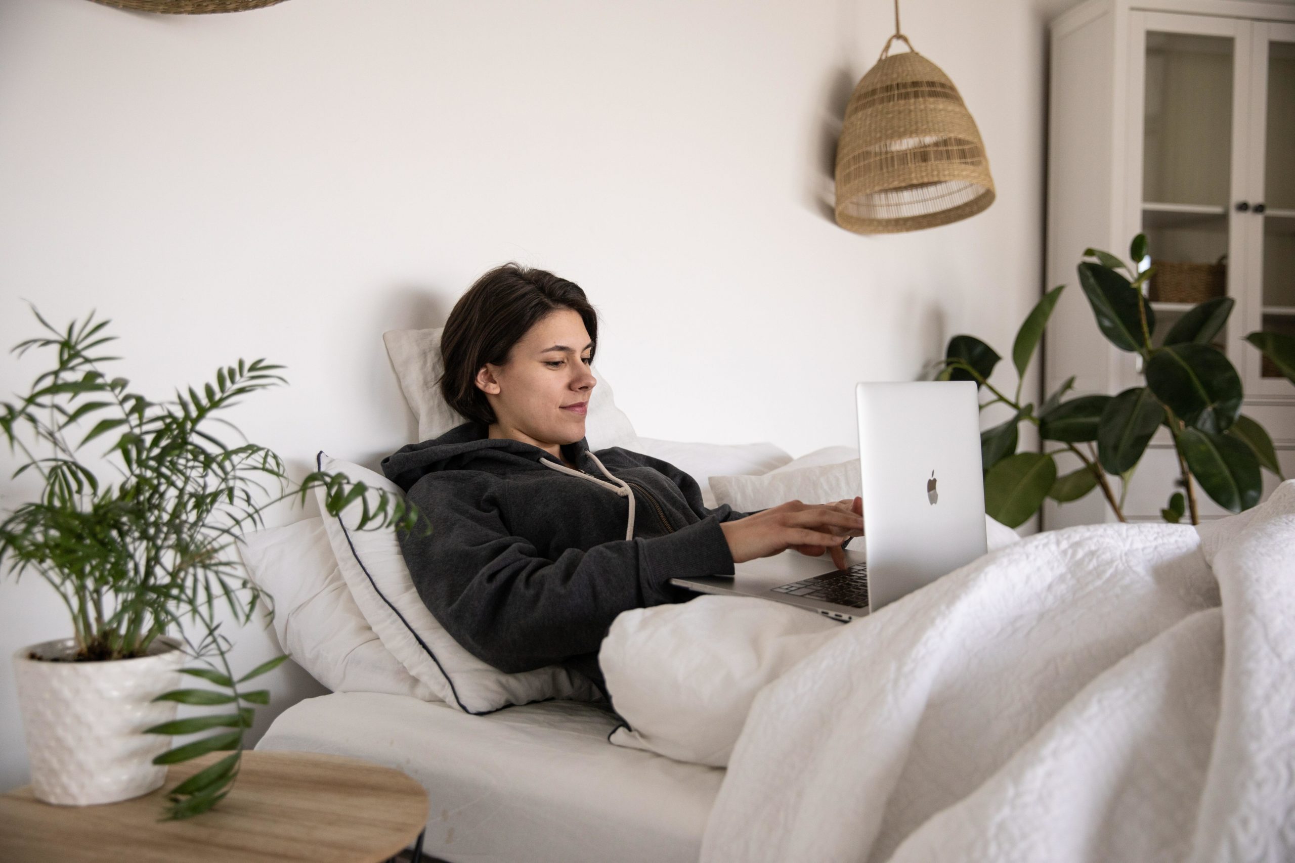 Girl in bed looking at laptop