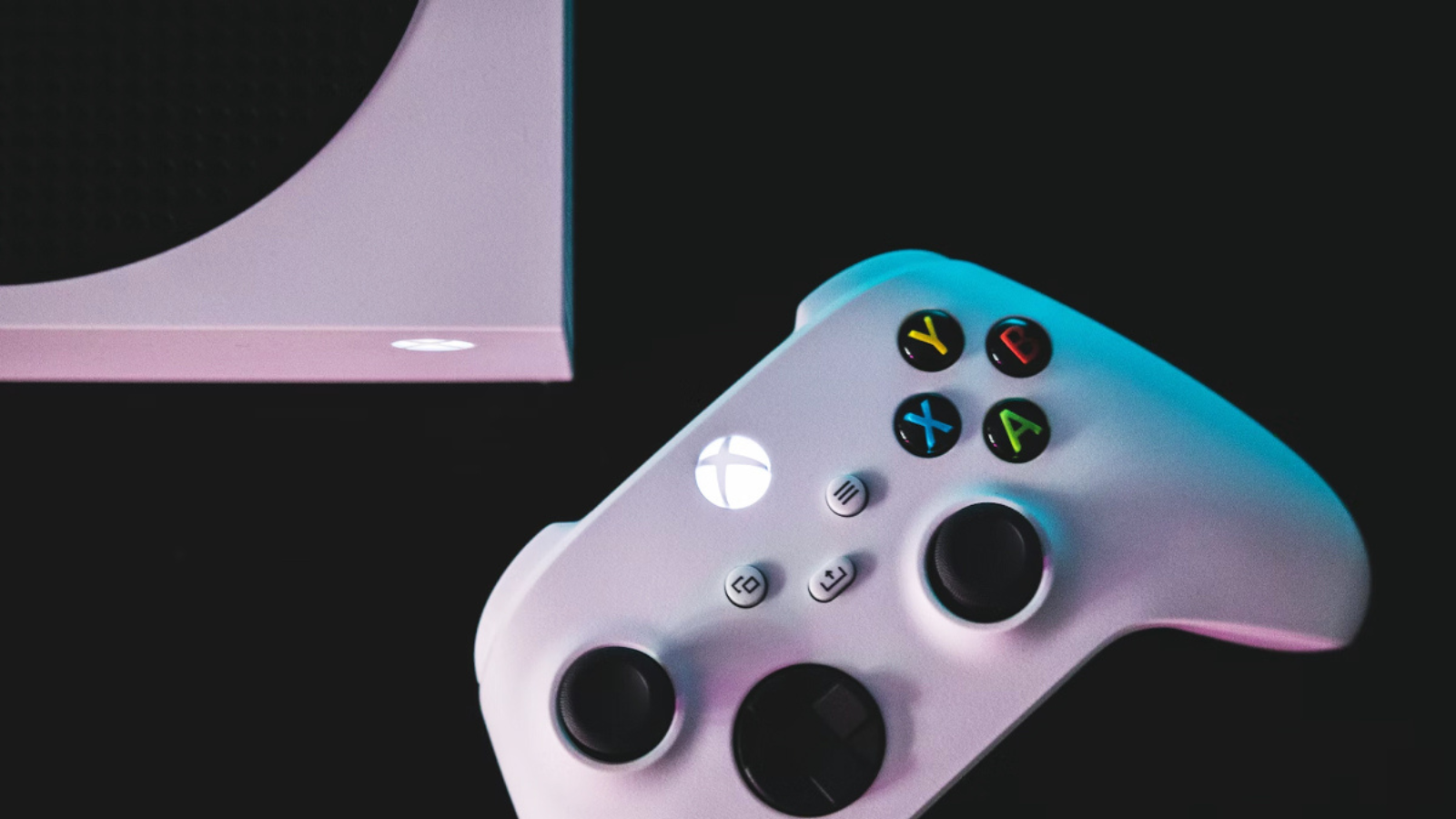 white xbox controller and console with black background