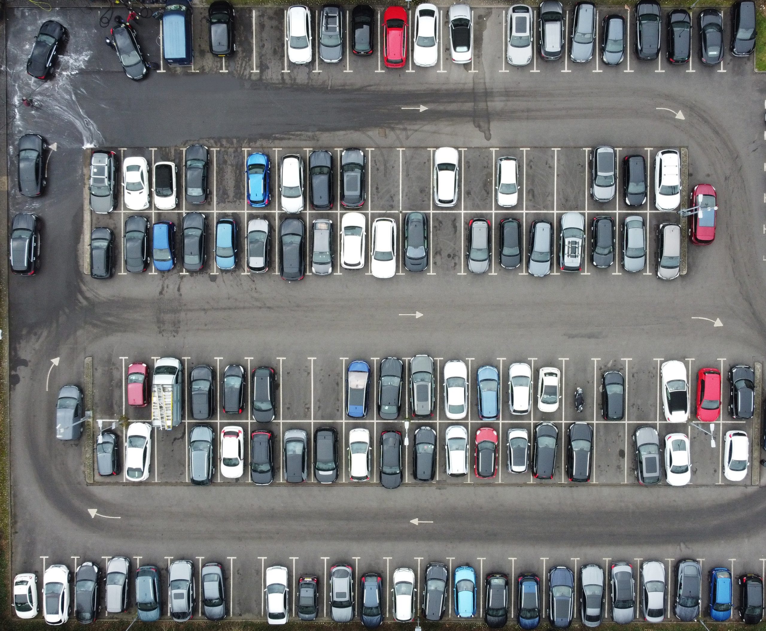 Overhead aerial view of a car park full with cars