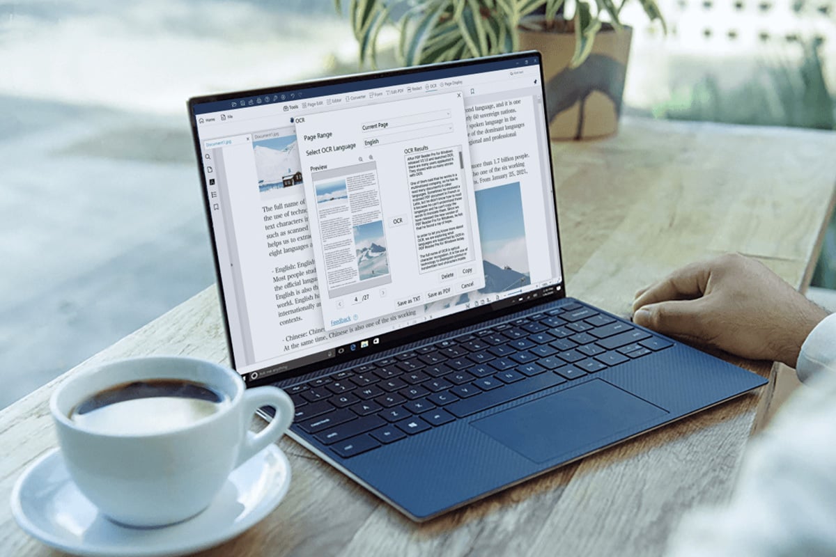 sleek black laptop is on top of a wooden coffee table, in between a hand and a cup of coffee, the pdf editor is on the screen