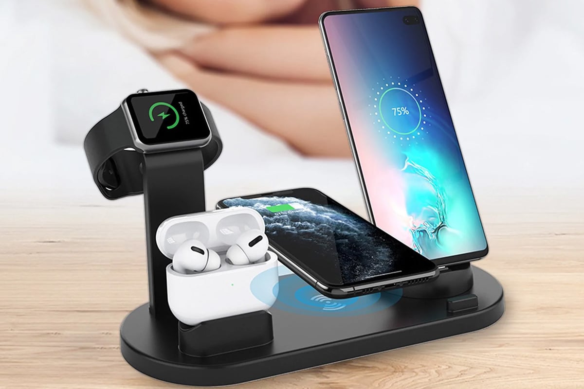 multiplatform charging station holding and charging an iphone, airpods, smart watch, and android phone