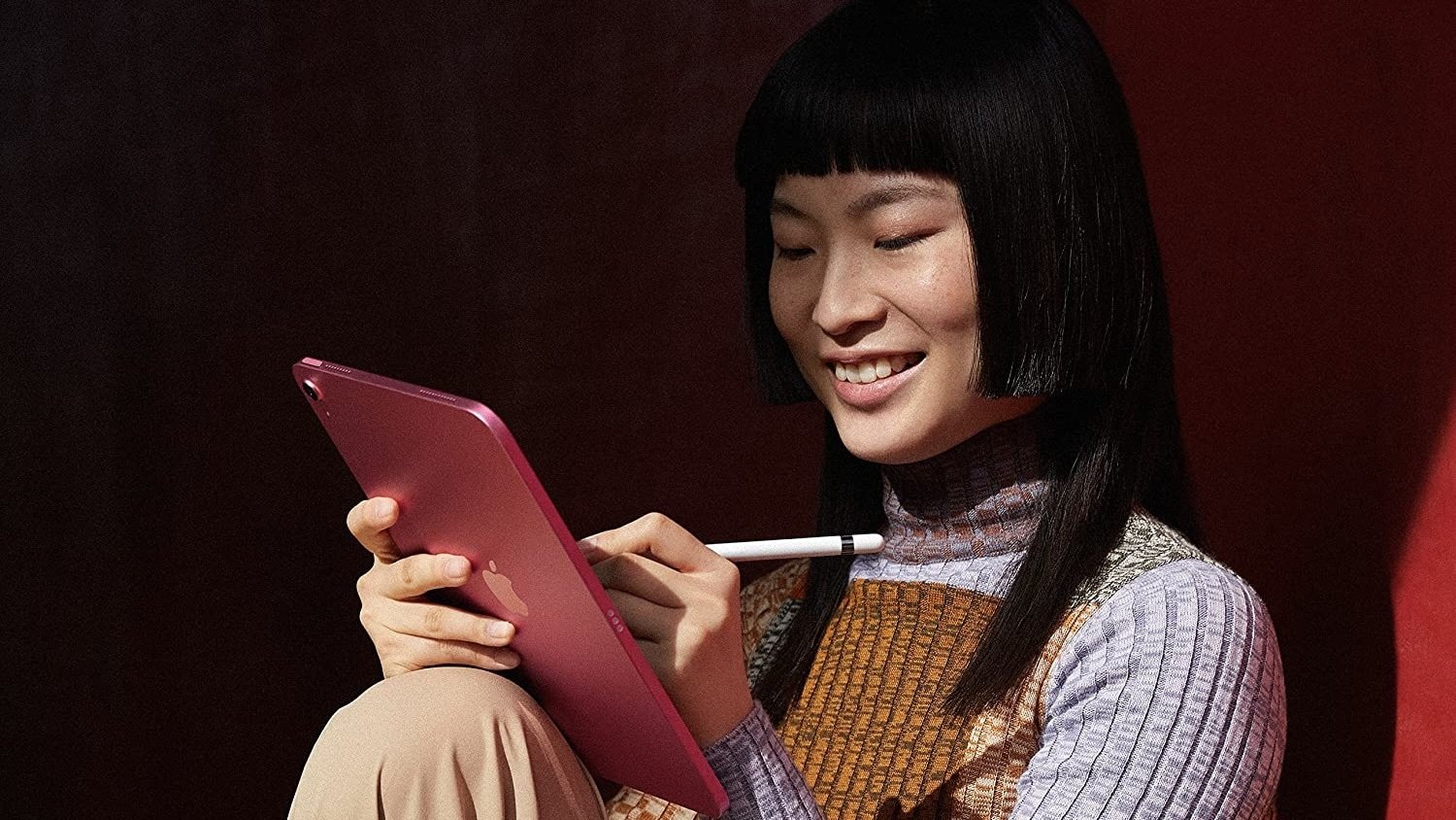 woman writing on pink ipad with apple pencil
