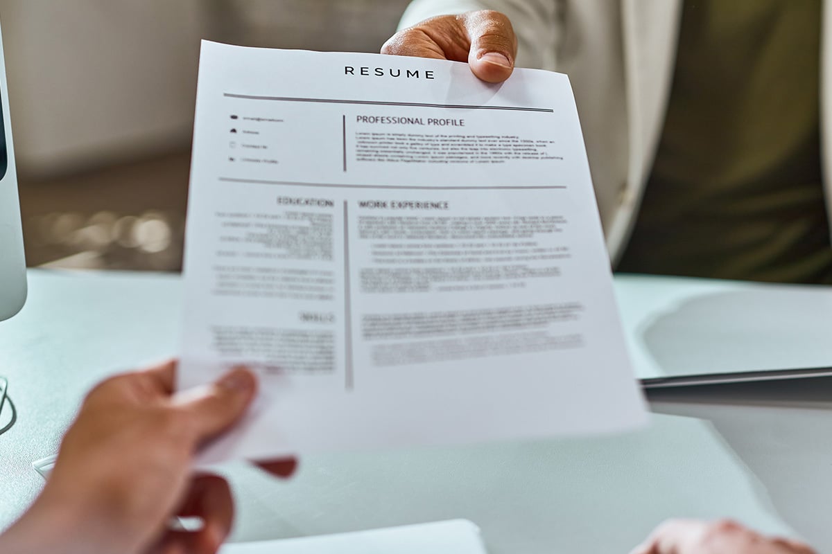 a resume being handed from one person to another