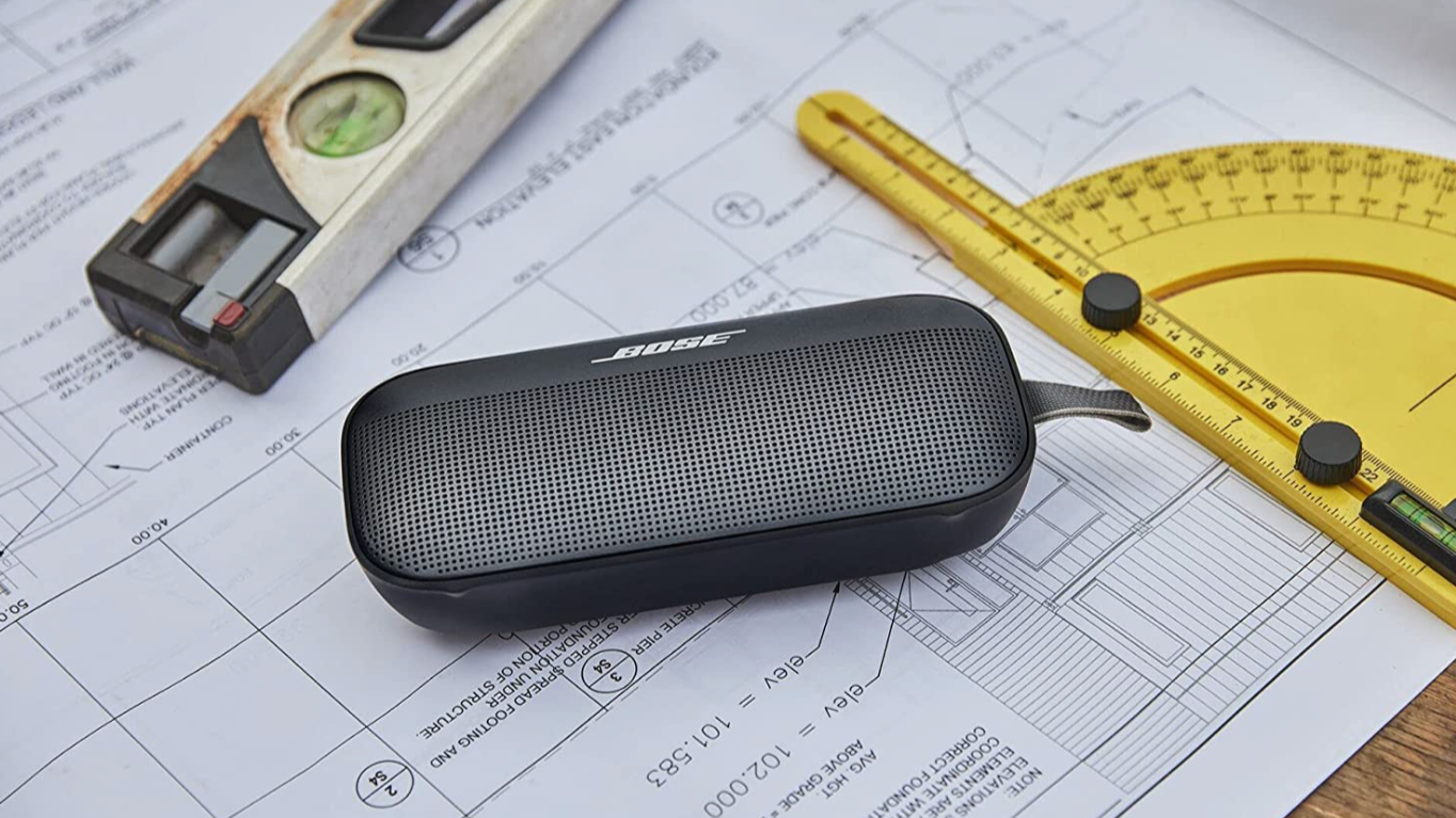Black blueetoth speaker on a desk with a ruler and protractor