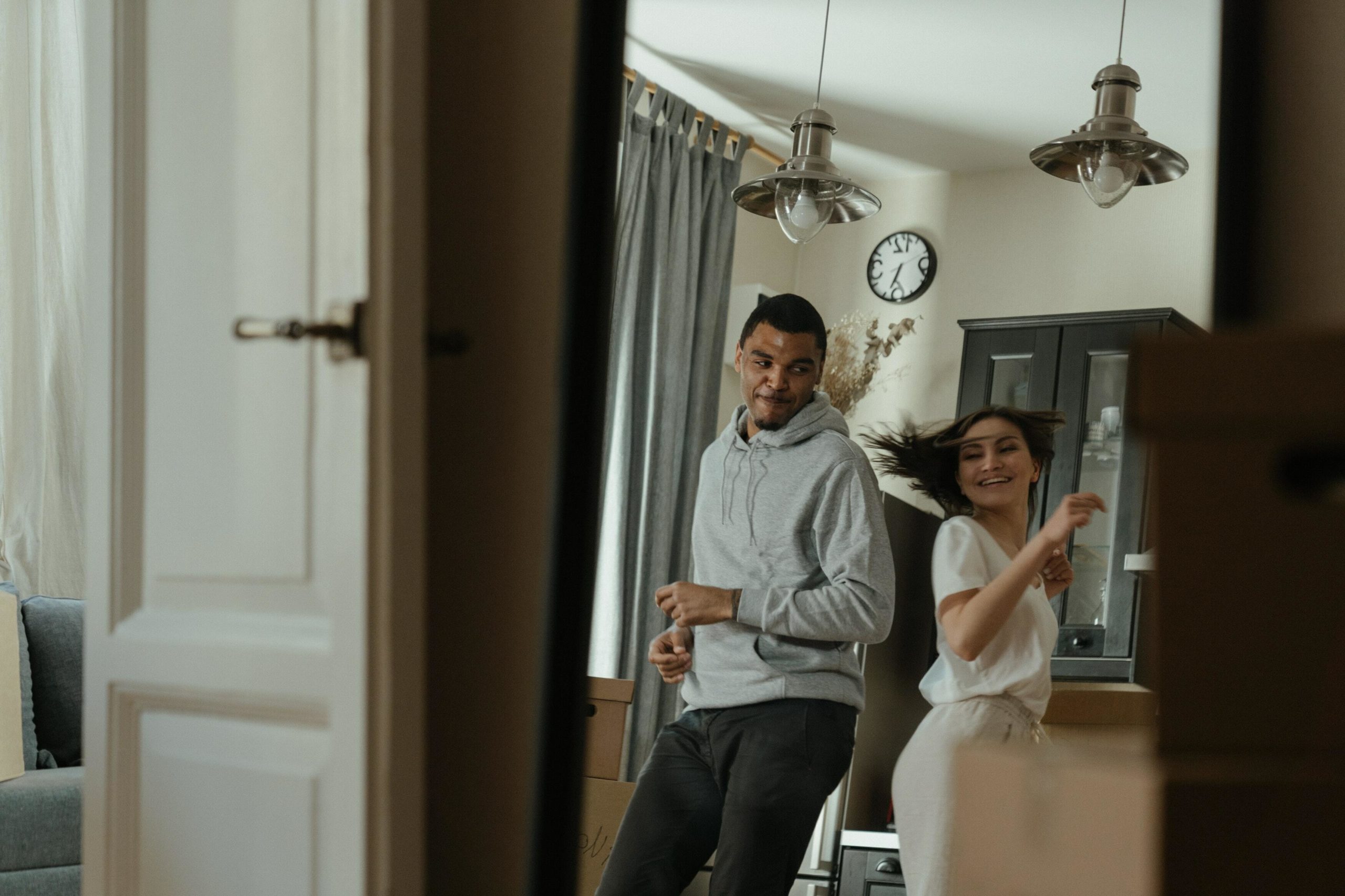 A man and woman dance in an apartment.