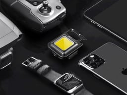 portable utility flashlight next to iphone, smatwatch, camera, and other gadgets 
