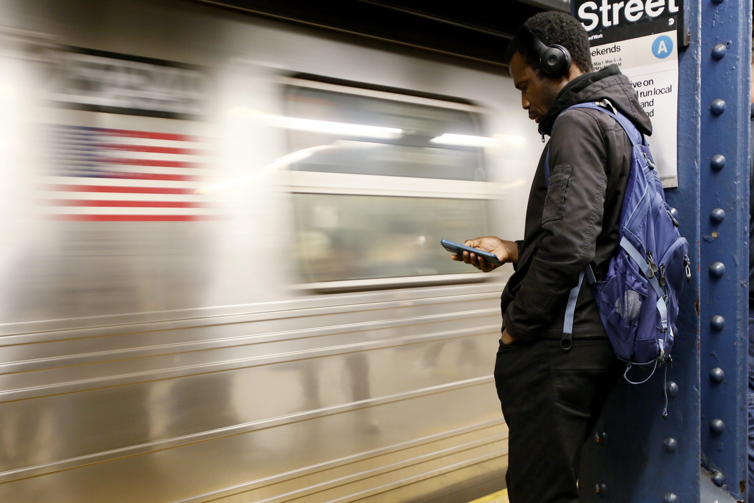 Subway rider checks his phone